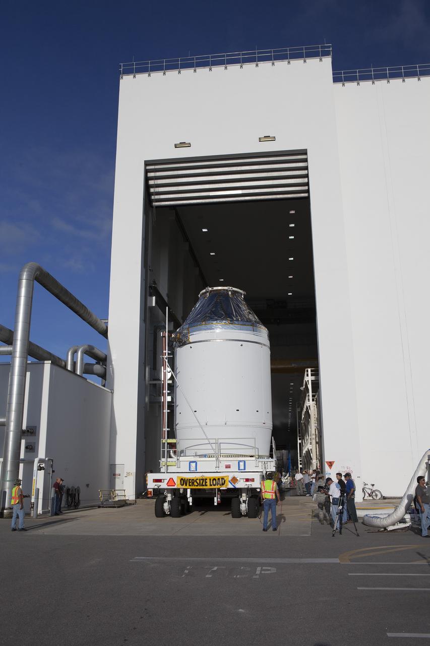 CAPE CANAVERAL, Fla. – The Orion crew module, stacked atop its service module, is slowly transported through the Neil Armstrong Operations and Checkout Building high bay door at NASA's Kennedy Space Center in Florida. The spacecraft for Exploration Flight Test-1 will be transported to the Payload Hazardous Servicing Facility where it will be fueled ahead of its December flight test.    Orion is the exploration spacecraft designed to carry astronauts to destinations not yet explored by humans, including an asteroid and Mars. It will have emergency abort capability, sustain the crew during space travel and provide safe re-entry from deep space return velocities. The first unpiloted test flight of the Orion is scheduled to launch atop a United Launch Alliance Delta IV Heavy rocket from Cape Canaveral Air Force Station in Florida to an altitude of 3,600 miles above the Earth's surface. The two-orbit, four-hour flight test will help engineers evaluate the systems critical to crew safety including the heat shield, parachute system and launch abort system. For more information, visit http://www.nasa.gov/orion. Photo credit: NASA/Daniel Casper