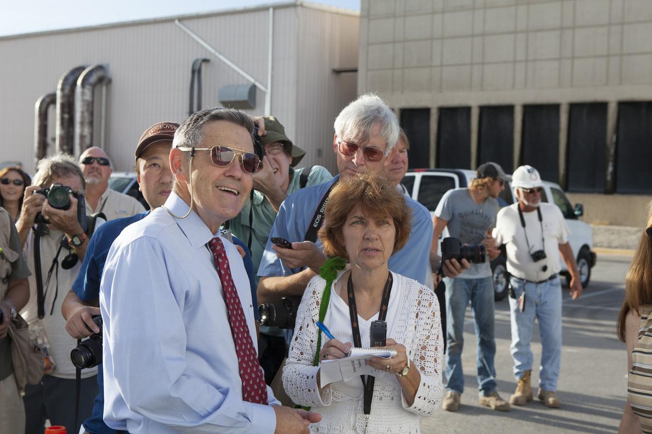 CAPE CANAVERAL, Fla. – Kennedy Space Center Director Bob Cabana, at left, watches with reporters and photographers as the Orion crew module, stacked atop its service module, moves out of the Neil Armstrong Operations and Checkout Building high bay at NASA's Kennedy Space Center in Florida. The spacecraft for Exploration Flight Test-1 will be transported to the Payload Hazardous Servicing Facility where it will be fueled ahead of its December flight test.     Orion is the exploration spacecraft designed to carry astronauts to destinations not yet explored by humans, including an asteroid and Mars. It will have emergency abort capability, sustain the crew during space travel and provide safe re-entry from deep space return velocities. The first unpiloted test flight of the Orion is scheduled to launch atop a United Launch Alliance Delta IV Heavy rocket from Cape Canaveral Air Force Station in Florida to an altitude of 3,600 miles above the Earth's surface. The two-orbit, four-hour flight test will help engineers evaluate the systems critical to crew safety including the heat shield, parachute system and launch abort system. For more information, visit http://www.nasa.gov/orion. Photo credit: NASA/Daniel Casper