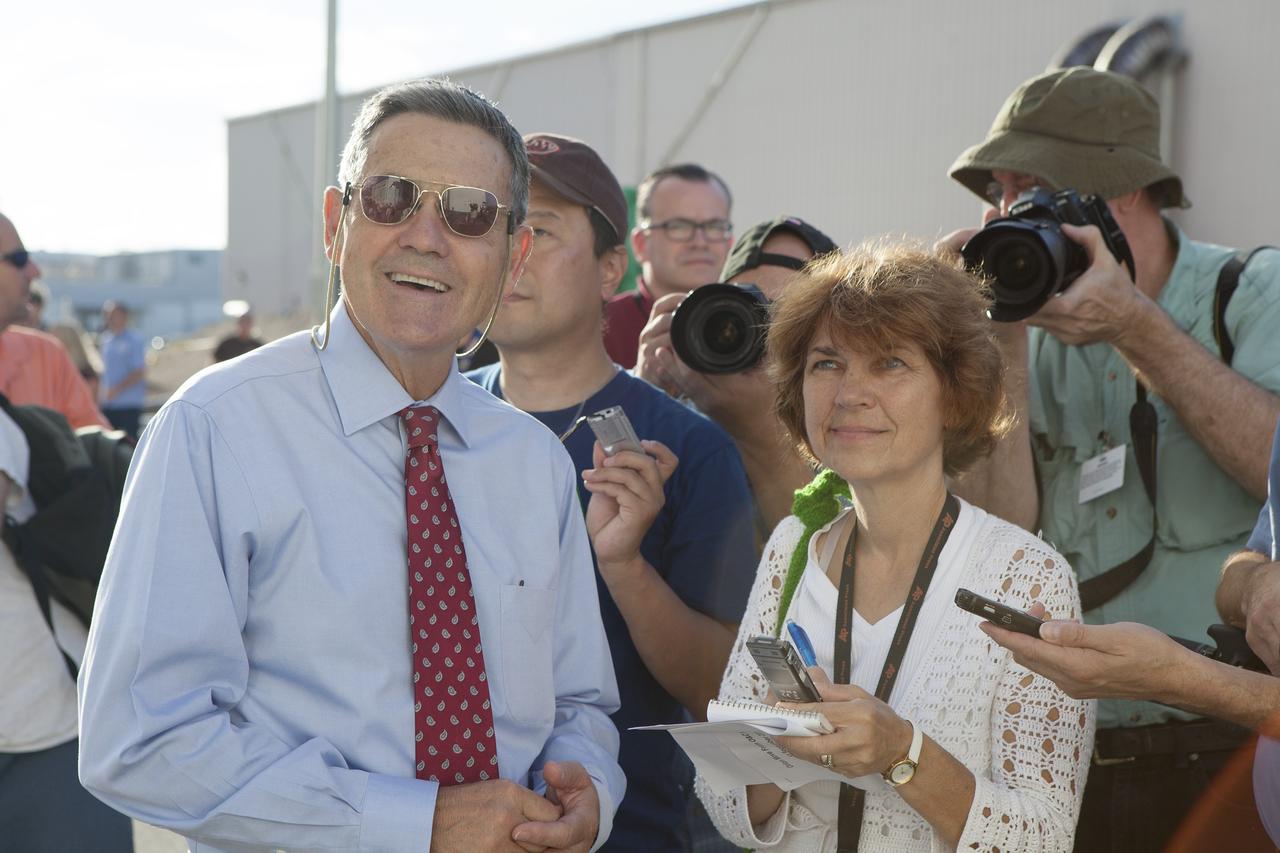 CAPE CANAVERAL, Fla. – Kennedy Space Center Director Bob Cabana, at left, watches with reporters and photographers as the Orion crew module, stacked atop its service module, moves out of the Neil Armstrong Operations and Checkout Building high bay at NASA's Kennedy Space Center in Florida. The spacecraft for Exploration Flight Test-1 will be transported to the Payload Hazardous Servicing Facility where it will be fueled ahead of its December flight test. Orion is the exploration spacecraft designed to carry astronauts to destinations not yet explored by humans, including an asteroid and Mars. It will have emergency abort capability, sustain the crew during space travel and provide safe re-entry from deep space return velocities. The first unpiloted test flight of the Orion is scheduled to launch atop a United Launch Alliance Delta IV Heavy rocket from Cape Canaveral Air Force Station in Florida to an altitude of 3,600 miles above the Earth's surface. The two-orbit, four-hour flight test will help engineers evaluate the systems critical to crew safety including the heat shield, parachute system and launch abort system. For more information, visit http://www.nasa.gov/orion. Photo credit: NASA/Daniel Casper