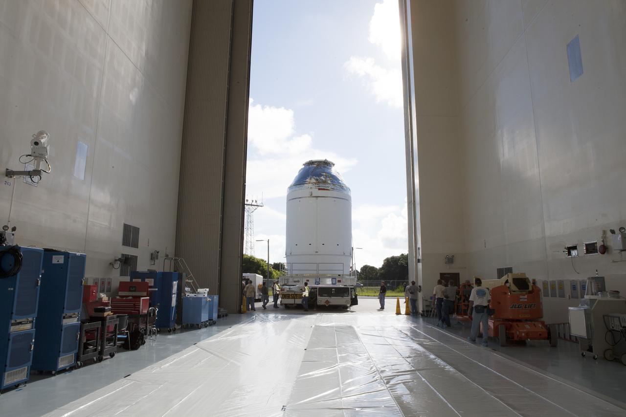 CAPE CANAVERAL, Fla. – The Orion crew module, stacked atop its service module, is transported into the Payload Hazardous Servicing Facility at NASA's Kennedy Space Center in Florida, where it will be fueled ahead of its December flight. The spacecraft for Exploration Flight Test-1 was moved out of the Neil Armstrong Operations and Checkout Building high bay.    Orion is the exploration spacecraft designed to carry astronauts to destinations not yet explored by humans, including an asteroid and Mars. It will have emergency abort capability, sustain the crew during space travel and provide safe re-entry from deep space return velocities. The first unpiloted test flight of the Orion is scheduled to launch atop a United Launch Alliance Delta IV Heavy rocket from Cape Canaveral Air Force Station in Florida to an altitude of 3,600 miles above the Earth's surface. The two-orbit, four-hour flight test will help engineers evaluate the systems critical to crew safety including the heat shield, parachute system and launch abort system. For more information, visit http://www.nasa.gov/orion. Photo credit: NASA/Daniel Casper