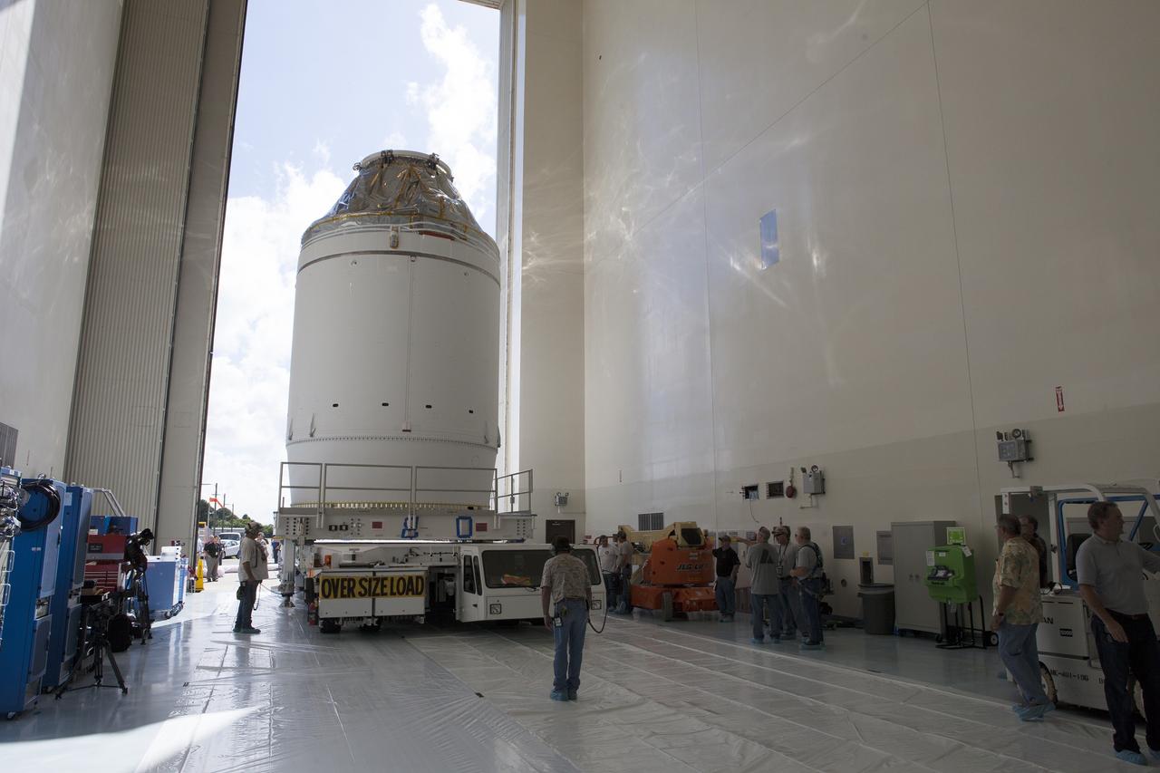 CAPE CANAVERAL, Fla. – The Orion crew module, stacked atop its service module, is transported into the Payload Hazardous Servicing Facility at NASA's Kennedy Space Center in Florida, where it will be fueled ahead of its December flight. The spacecraft for Exploration Flight Test-1 was moved out of the Neil Armstrong Operations and Checkout Building high bay. Orion is the exploration spacecraft designed to carry astronauts to destinations not yet explored by humans, including an asteroid and Mars. It will have emergency abort capability, sustain the crew during space travel and provide safe re-entry from deep space return velocities. The first unpiloted test flight of the Orion is scheduled to launch atop a United Launch Alliance Delta IV Heavy rocket from Cape Canaveral Air Force Station in Florida to an altitude of 3,600 miles above the Earth's surface. The two-orbit, four-hour flight test will help engineers evaluate the systems critical to crew safety including the heat shield, parachute system and launch abort system. For more information, visit http://www.nasa.gov/orion. Photo credit: NASA/Daniel Casper