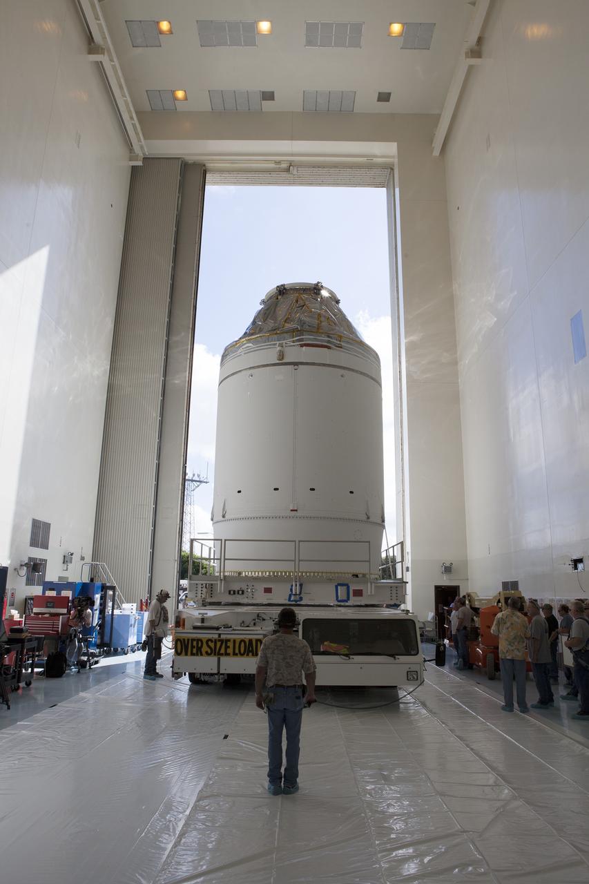 CAPE CANAVERAL, Fla. – The Orion crew module, stacked atop its service module, is transported into the Payload Hazardous Servicing Facility at NASA's Kennedy Space Center in Florida, where it will be fueled ahead of its December flight. The spacecraft for Exploration Flight Test-1 was moved out of the Neil Armstrong Operations and Checkout Building high bay. Orion is the exploration spacecraft designed to carry astronauts to destinations not yet explored by humans, including an asteroid and Mars. It will have emergency abort capability, sustain the crew during space travel and provide safe re-entry from deep space return velocities. The first unpiloted test flight of the Orion is scheduled to launch atop a United Launch Alliance Delta IV Heavy rocket from Cape Canaveral Air Force Station in Florida to an altitude of 3,600 miles above the Earth's surface. The two-orbit, four-hour flight test will help engineers evaluate the systems critical to crew safety including the heat shield, parachute system and launch abort system. For more information, visit http://www.nasa.gov/orion. Photo credit: NASA/Daniel Casper