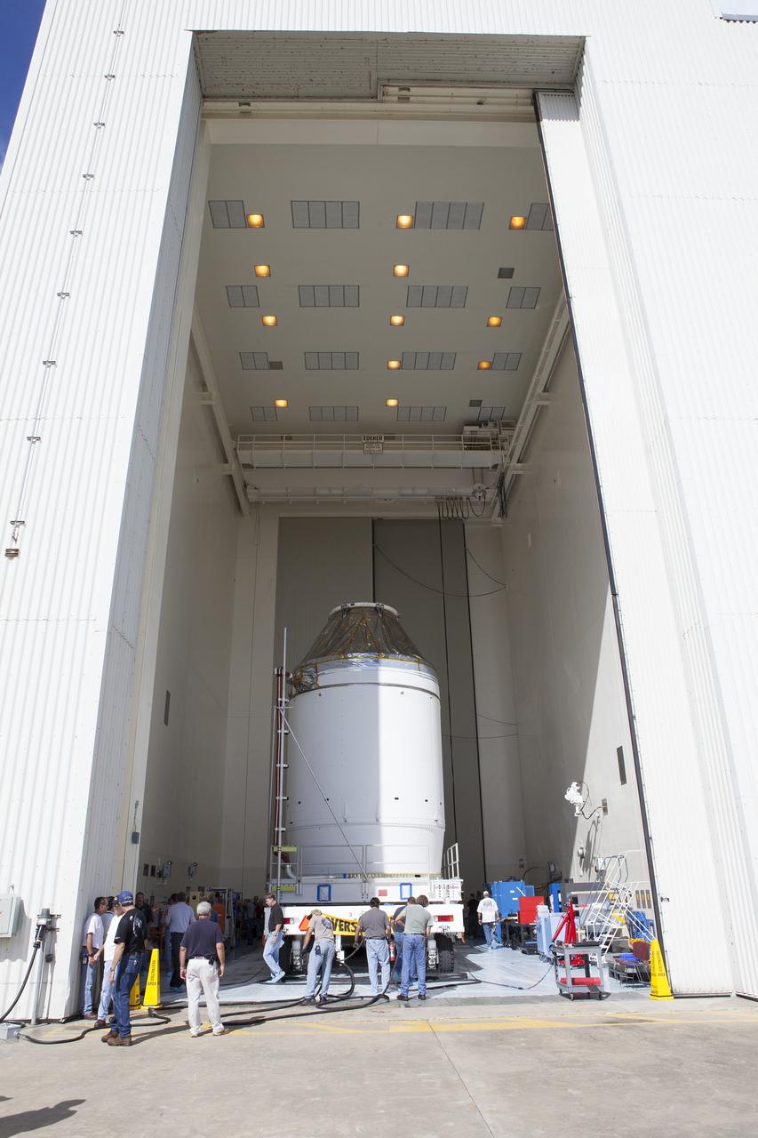 CAPE CANAVERAL, Fla. – Technicians assist as the Orion crew module, stacked atop its service module, is moved into the Payload Hazardous Servicing Facility at NASA's Kennedy Space Center in Florida, where it will be fueled ahead of its December flight. The spacecraft for Exploration Flight Test-1 was moved out of the Neil Armstrong Operations and Checkout Building high bay. Orion is the exploration spacecraft designed to carry astronauts to destinations not yet explored by humans, including an asteroid and Mars. It will have emergency abort capability, sustain the crew during space travel and provide safe re-entry from deep space return velocities. The first unpiloted test flight of the Orion is scheduled to launch atop a United Launch Alliance Delta IV Heavy rocket from Cape Canaveral Air Force Station in Florida to an altitude of 3,600 miles above the Earth's surface. The two-orbit, four-hour flight test will help engineers evaluate the systems critical to crew safety including the heat shield, parachute system and launch abort system. For more information, visit http://www.nasa.gov/orion. Photo credit: NASA/Daniel Casper