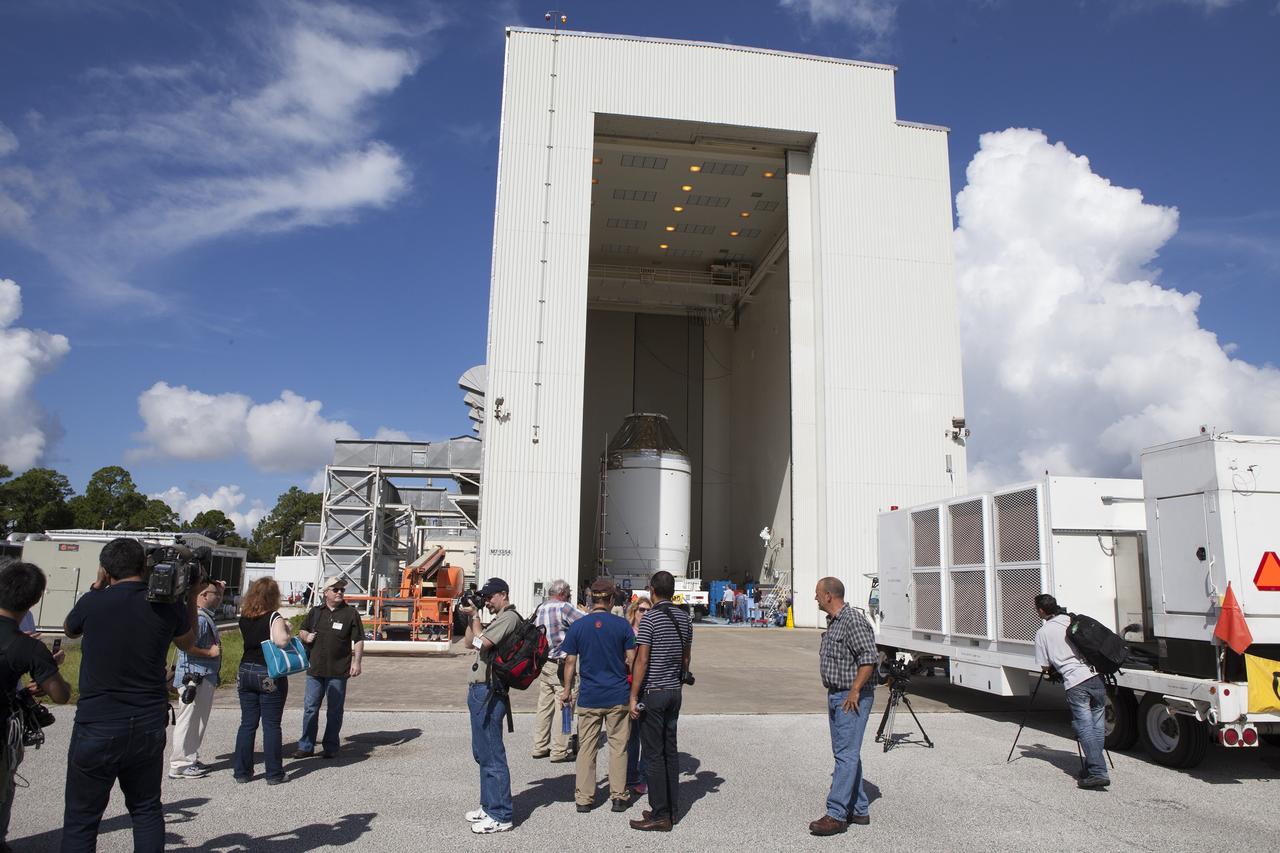 CAPE CANAVERAL, Fla. – Reporters and photographers watch as the Orion crew module, stacked atop its service module, is transported into the Payload Hazardous Servicing Facility at NASA's Kennedy Space Center in Florida, where it will be fueled ahead of its December flight. The spacecraft for Exploration Flight Test-1 was moved out of the Neil Armstrong Operations and Checkout Building high bay. Orion is the exploration spacecraft designed to carry astronauts to destinations not yet explored by humans, including an asteroid and Mars. It will have emergency abort capability, sustain the crew during space travel and provide safe re-entry from deep space return velocities. The first unpiloted test flight of the Orion is scheduled to launch atop a United Launch Alliance Delta IV Heavy rocket from Cape Canaveral Air Force Station in Florida to an altitude of 3,600 miles above the Earth's surface. The two-orbit, four-hour flight test will help engineers evaluate the systems critical to crew safety including the heat shield, parachute system and launch abort system. For more information, visit http://www.nasa.gov/orion. Photo credit: NASA/Daniel Casper