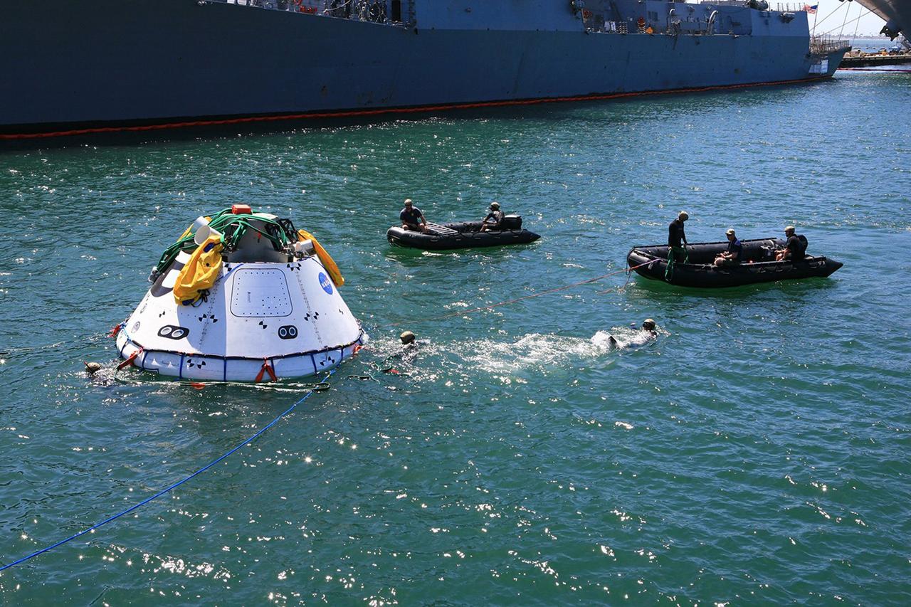 SAN DIEGO, Calif. – The Orion boilerplate test vehicle has been lowered into the water with a stationary crane from the USS Salvor, a safeguard-class rescue and salvage ship, during the first day of Underway Recovery Test 4A at Naval Base San Diego in California. U.S. Navy personnel in two Zodiac boats practice procedures to tether and retrieve the test vehicle. The ship will head out to sea for four days to test crew module crane recovery operations. NASA, Lockheed Martin and the U.S. Navy are conducting the test to prepare for recovery of the Orion crew module on its return from a deep space mission. The underway recovery test will allow the teams to demonstrate and evaluate the recovery processes, procedures, new hardware and personnel in open waters. The Ground Systems Development and Operations Program is conducting the underway recovery test. Orion is the exploration spacecraft designed to carry astronauts to destinations not yet explored by humans, including an asteroid and Mars. It will have emergency abort capability, sustain the crew during space travel and provide safe re-entry from deep space return velocities. The first unpiloted test flight of the Orion is scheduled to launch in December 2014 atop a United Launch Alliance Delta IV rocket and in 2018 on NASA’s Space Launch System rocket. For more information, visit http://www.nasa.gov/orion. Photo credit: Kim Shiflett