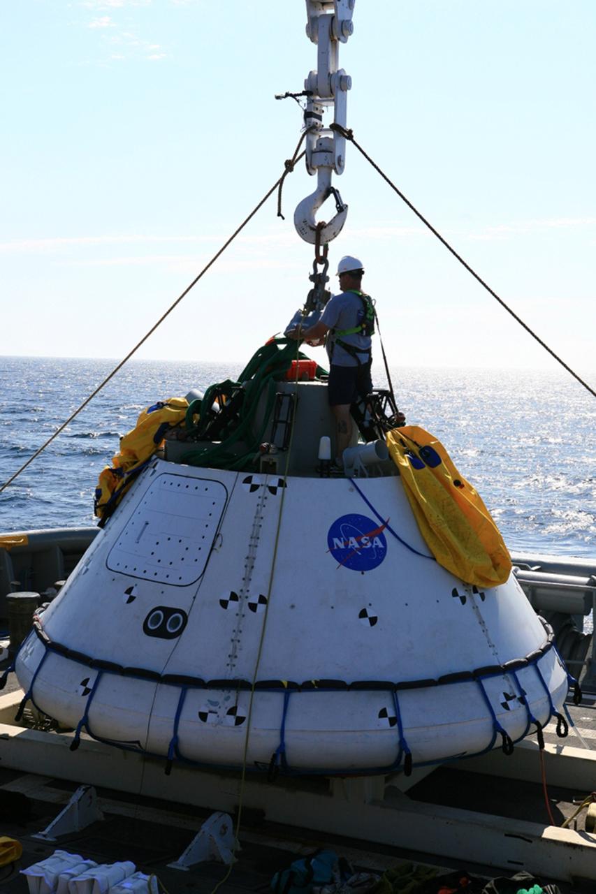SAN DIEGO, Calif. – On board the USS Salvor, a safeguard-class rescue and salvage ship, U.S. Navy personnel check the stationary crane attached to the Orion boilerplate test vehicle during Underway Recovery Test 4A in the Pacific Ocean. The test vehicle will be lifted up and lowered into the water to test crew module crane recovery operations. NASA, Lockheed Martin and the U.S. Navy are conducting the test to prepare for recovery of the Orion crew module on its return from a deep space mission. The underway recovery test will allow the teams to demonstrate and evaluate the recovery processes, procedures, new hardware and personnel in open waters. The Ground Systems Development and Operations Program is conducting the underway recovery test. Orion is the exploration spacecraft designed to carry astronauts to destinations not yet explored by humans, including an asteroid and Mars. It will have emergency abort capability, sustain the crew during space travel and provide safe re-entry from deep space return velocities. The first unpiloted test flight of the Orion is scheduled to launch in December 2014 atop a United Launch Alliance Delta IV Heavy rocket and in 2018 on NASA’s Space Launch System rocket. For more information, visit http://www.nasa.gov/orion. Photo credit: Kim Shiflett