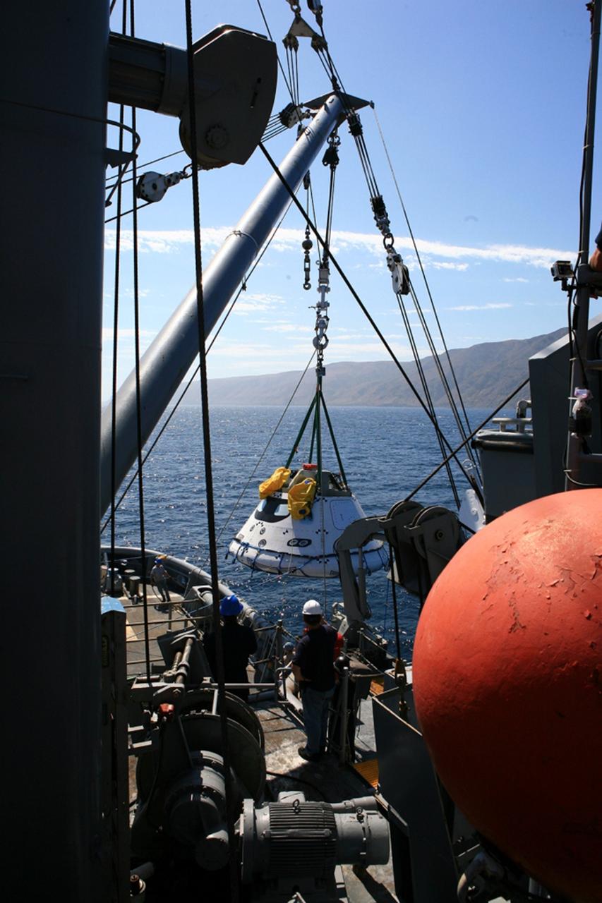 SAN DIEGO, Calif. – On board the USS Salvor, a safeguard-class rescue and salvage ship, U.S. Navy personnel monitor the progress as a stationary crane lowers the Orion boilerplate test vehicle into the Pacific Ocean during Underway Recovery Test 4A. NASA, Lockheed Martin and the U.S. Navy are testing crane recovery operations to prepare for recovery of the Orion crew module on its return from a deep space mission. The underway recovery test will allow the teams to demonstrate and evaluate the recovery processes, procedures, new hardware and personnel in open waters. The Ground Systems Development and Operations Program is conducting the underway recovery test. Orion is the exploration spacecraft designed to carry astronauts to destinations not yet explored by humans, including an asteroid and Mars. It will have emergency abort capability, sustain the crew during space travel and provide safe re-entry from deep space return velocities. The first unpiloted test flight of the Orion is scheduled to launch in December 2014 atop a United Launch Alliance Delta IV Heavy rocket and in 2018 on NASA’s Space Launch System rocket. For more information, visit http://www.nasa.gov/orion. Photo credit: Kim Shiflett