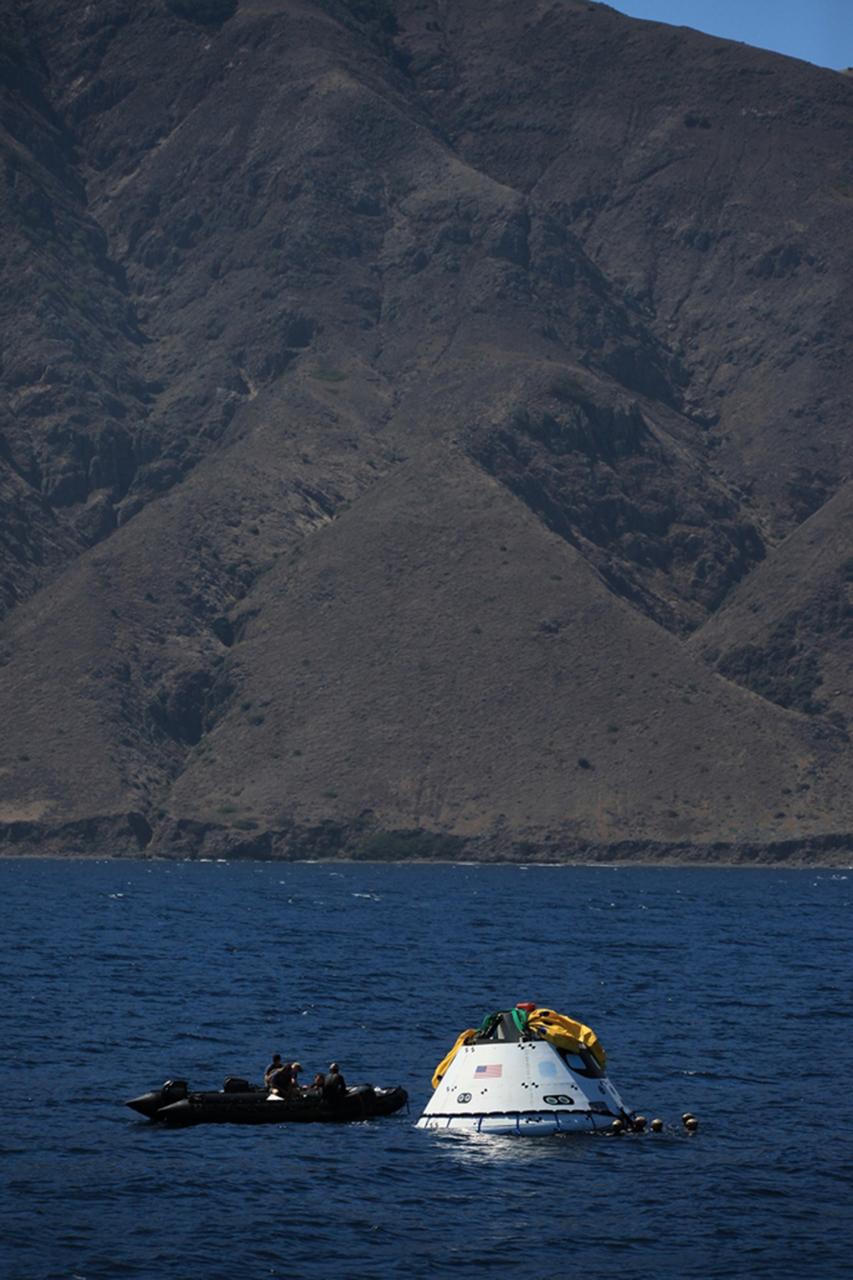 SAN DIEGO, Calif. – The Orion boilerplate test vehicle floats in the Pacific Ocean during Underway Recovery Test 4A. Orion was lowered into the water with a stationary crane from the USS Salvor, a safeguard-class rescue and salvage ship. Nearby, U.S. Navy personnel in a Zodiac boat prepare to practice procedures to tether and retrieve the test vehicle. NASA, Lockheed Martin and the U.S. Navy are conducting crane recovery tests to prepare for recovery of the Orion crew module on its return from a deep space mission. The underway recovery test will allow the teams to demonstrate and evaluate the recovery processes, procedures, new hardware and personnel in open waters. The Ground Systems Development and Operations Program is conducting the underway recovery test. Orion is the exploration spacecraft designed to carry astronauts to destinations not yet explored by humans, including an asteroid and Mars. It will have emergency abort capability, sustain the crew during space travel and provide safe re-entry from deep space return velocities. The first unpiloted test flight of the Orion is scheduled to launch in December 2014 atop a United Launch Alliance Delta IV Heavy rocket and in 2018 on NASA’s Space Launch System rocket. For more information, visit http://www.nasa.gov/orion. Photo credit: Kim Shiflett