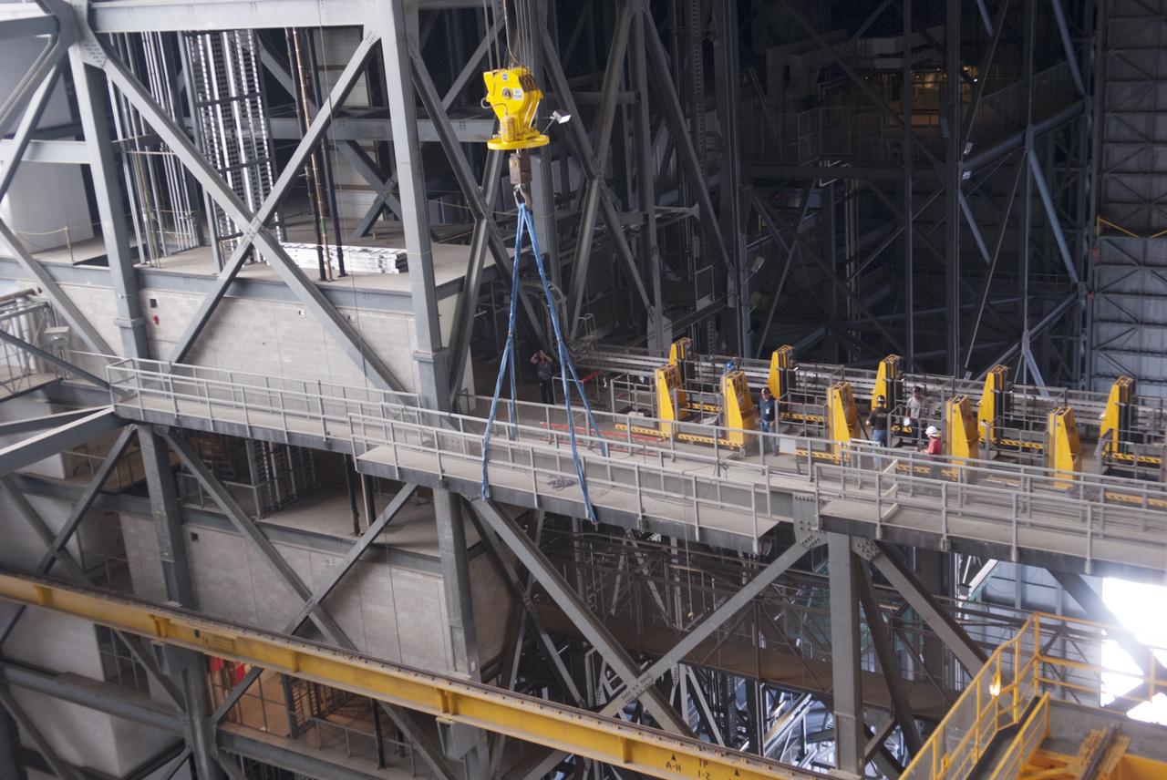 CAPE CANAVERAL, Fla. – Inside the Vehicle Assembly Building, or VAB, at NASA's Kennedy Space Center in Florida, a crane is used to remove a portion of the catwalk on the west side of Level 16. The catwalk is being removed to allow room for the removal of the 175-ton crane that is situated above the transfer aisle. The crane will be lowered to the floor to perform upgrades to its 45-year-old controls in order to improve reliability, precision and safety. The Ground Systems Development and Operations Program is overseeing upgrades and modifications to the VAB. The crane will be upgraded so that it can support lifting needs for NASA and other exploration vehicles, including the agency's Space Launch System and Orion spacecraft. Photo credit: NASA/Jim Grossmann