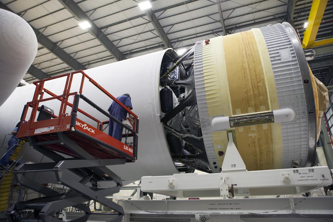CAPE CANAVERAL, Fla. – Inside the Horizontal Integration Facility at Space Launch Complex 37 at Cape Canaveral Air Force Station in Florida, a United Launch Alliance technician on a scissor lift monitors the progress as the second stage of a Delta IV Heavy rocket is mated to the central core booster of the three booster stages for the unpiloted Exploration Flight Test-1, or EFT-1. During the mission, Orion will travel farther into space than any human spacecraft has gone in more than 40 years. The data gathered during the flight will influence design decisions, validate existing computer models and innovative new approaches to space systems development, as well as reduce overall mission risks and costs for later Orion flights. Liftoff of Orion on the first flight test is planned for December 2014. Photo credit: NASA/Daniel Casper