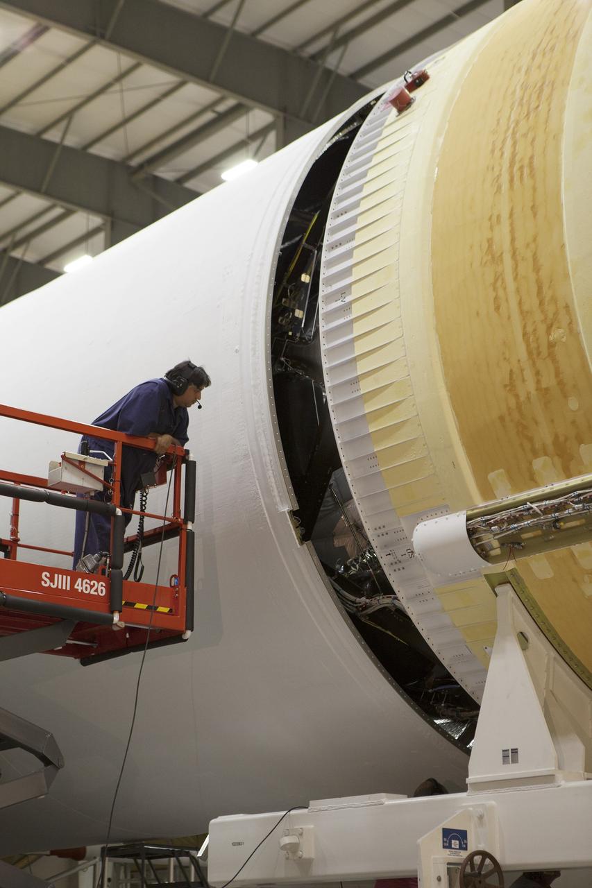CAPE CANAVERAL, Fla. – Inside the Horizontal Integration Facility at Space Launch Complex 37 at Cape Canaveral Air Force Station in Florida, a United Launch Alliance technician on a scissor lift monitors the progress as the second stage of a Delta IV Heavy rocket is mated to the central core booster of the three booster stages for the unpiloted Exploration Flight Test-1, or EFT-1. During the mission, Orion will travel farther into space than any human spacecraft has gone in more than 40 years. The data gathered during the flight will influence design decisions, validate existing computer models and innovative new approaches to space systems development, as well as reduce overall mission risks and costs for later Orion flights. Liftoff of Orion on the first flight test is planned for December 2014. Photo credit: NASA/Daniel Casper