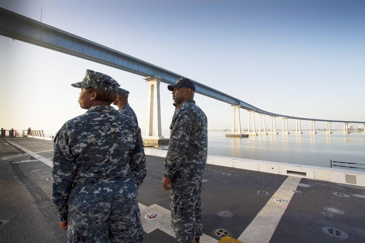 SAN DIEGO, Calif. – U.S. Navy personnel stand on the deck of the USS Anchorage as the ship departs Naval Base San Diego on the first day of Orion Underway Recovery Test 3. The ship will head out to sea, off the coast of San Diego, in search of conditions to support test needs for a full dress rehearsal of recovery operations. NASA, Lockheed Martin and U.S. Navy personnel will conduct tests in the Pacific Ocean to prepare for recovery of the Orion crew module on its return from a deep space mission. The test will allow the teams to demonstrate and evaluate the recovery processes, procedures, hardware and personnel in open waters. The Ground Systems Development and Operations Program is conducting the underway recovery tests. Orion is the exploration spacecraft designed to carry astronauts to destinations not yet explored by humans, including an asteroid and Mars. It will have emergency abort capability, sustain the crew during space travel and provide safe re-entry from deep space return velocities. The first unpiloted test flight of Orion is scheduled to launch in 2014 atop a United Launch Alliance Delta IV Heavy rocket and in 2018 on NASA’s Space Launch System rocket. For more information, visit http://www.nasa.gov/orion. Photo credit: NASA/Cory Huston