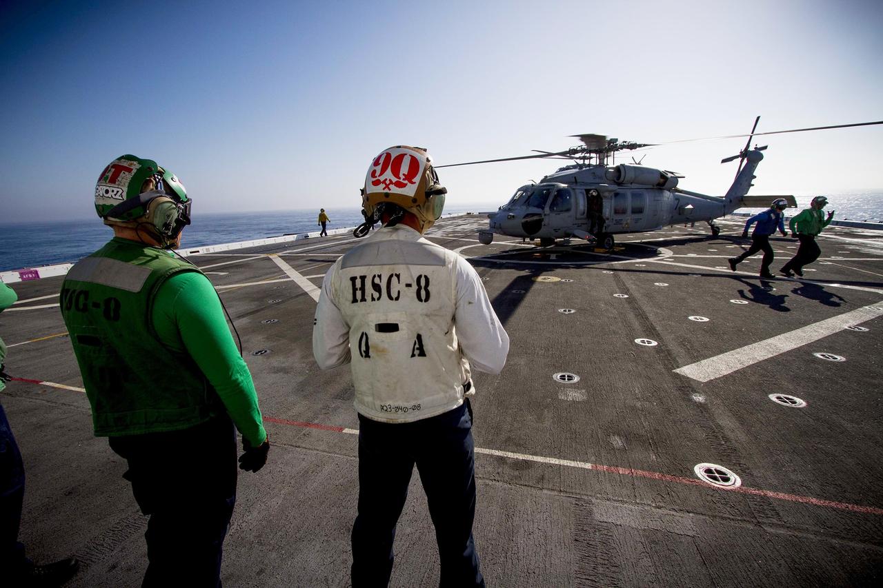 SAN DIEGO, Calif. – Helicopter Sea Combat Squadron 8, or HSC 8, prepare an H60-S Seahawk for flight on the deck of the USS Anchorage during the first day of Orion Underway Recovery Test 3 activities in the Pacific Ocean. NASA, Lockheed Martin and U.S. Navy personnel are conducting recovery tests to prepare for recovery of the Orion crew module on its return from a deep space mission. The test will allow the teams to demonstrate and evaluate the recovery processes, procedures, hardware and personnel in open waters.    The Ground Systems Development and Operations Program is conducting the underway recovery tests. Orion is the exploration spacecraft designed to carry astronauts to destinations not yet explored by humans, including an asteroid and Mars. It will have emergency abort capability, sustain the crew during space travel and provide safe re-entry from deep space return velocities. The first unpiloted test flight of Orion is scheduled to launch in 2014 atop a United Launch Alliance Delta IV Heavy rocket and in 2018 on NASA’s Space Launch System rocket. For more information, visit http://www.nasa.gov/orion. Photo credit: NASA/Cory Huston