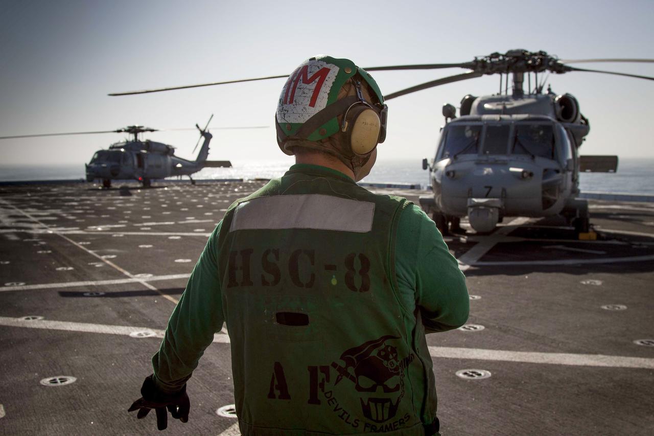 SAN DIEGO, Calif. – Helicopter Sea Combat Squadron 8, or HSC 8, prepare two H60-S helicopters for flight on the deck of the USS Anchorage during the first day of Orion Underway Recovery Test 3. The helicopters will be used during recovery of the Orion boilerplate test article. NASA, Lockheed Martin and U.S. Navy personnel are conducting recovery tests to prepare for recovery of the Orion crew module on its return from a deep space mission. The test will allow the teams to demonstrate and evaluate the recovery processes, procedures, hardware and personnel in open waters.    The Ground Systems Development and Operations Program is conducting the underway recovery tests. Orion is the exploration spacecraft designed to carry astronauts to destinations not yet explored by humans, including an asteroid and Mars. It will have emergency abort capability, sustain the crew during space travel and provide safe re-entry from deep space return velocities. The first unpiloted test flight of Orion is scheduled to launch in 2014 atop a United Launch Alliance Delta IV Heavy rocket and in 2018 on NASA’s Space Launch System rocket. For more information, visit http://www.nasa.gov/orion. Photo credit: NASA/Cory Huston