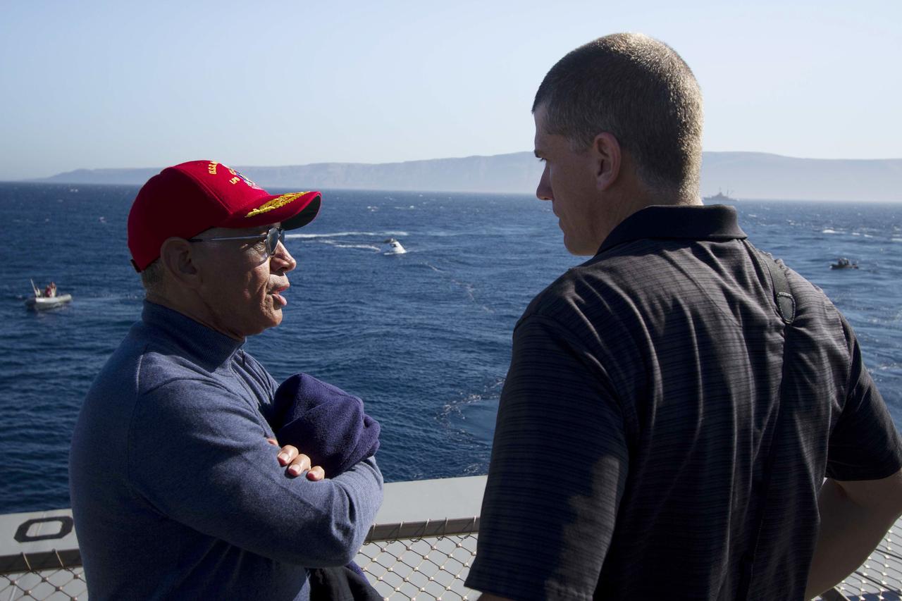 SAN DIEGO, Calif. – NASA Administrator Charlie Bolden, at left, talks to Jeremy Graeber, NASA Recovery director for Exploration Flight Test-1 Landing and Recovery Operations, on the deck of the USS Anchorage during Orion Underway Recovery Test 3. The Orion boilerplate test vehicle is in the Pacific Ocean with U.S. Navy divers nearby in Zodiac boats and rigid hull inflatable boats during recovery operations. NASA, Lockheed Martin and U.S. Navy personnel are conducting the test to prepare for recovery of the Orion crew module on its return from a deep space mission. The test will allow the teams to demonstrate and evaluate the recovery processes, procedures, hardware and personnel in open waters. The Ground Systems Development and Operations Program is conducting the underway recovery tests. Orion is the exploration spacecraft designed to carry astronauts to destinations not yet explored by humans, including an asteroid and Mars. It will have emergency abort capability, sustain the crew during space travel and provide safe re-entry from deep space return velocities. The first unpiloted test flight of Orion is scheduled to launch in 2014 atop a United Launch Alliance Delta IV Heavy rocket and in 2018 on NASA’s Space Launch System rocket. For more information, visit http://www.nasa.gov/orion. Photo credit: NASA/Cory Huston