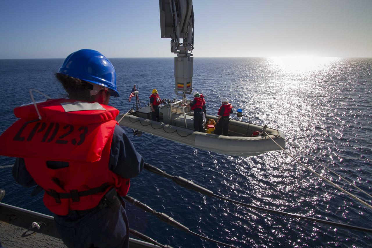 SAN DIEGO, Calif. – A rigid hull inflatable boat, with U.S. Navy personnel aboard, is being lowered into the water from the USS Anchorage on the second day of Orion Underway Recovery Test 3 in the Pacific Ocean. NASA, Lockheed Martin and U.S. Navy personnel are conducting recovery tests using the Orion boilerplate test vehicle to prepare for recovery of the Orion crew module on its return from a deep space mission. The test allows the teams to demonstrate and evaluate the recovery processes, procedures, hardware and personnel in open waters. The Ground Systems Development and Operations Program is conducting the underway recovery tests. Orion is the exploration spacecraft designed to carry astronauts to destinations not yet explored by humans, including an asteroid and Mars. It will have emergency abort capability, sustain the crew during space travel and provide safe re-entry from deep space return velocities. The first unpiloted test flight of Orion is scheduled to launch in 2014 atop a United Launch Alliance Delta IV Heavy rocket and in 2018 on NASA’s Space Launch System rocket. For more information, visit http://www.nasa.gov/orion. Photo credit: NASA/Cory Huston