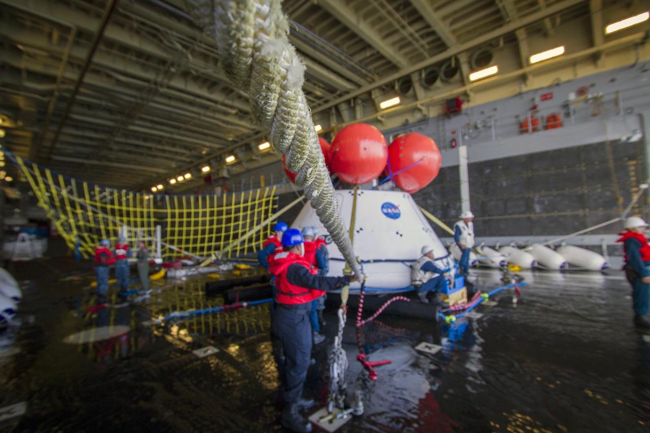 SAN DIEGO, Calif. – The Orion boilerplate test vehicle is tethered in the well deck of the USS Anchorage during the second day of Orion Underway Recovery Test 3 in the Pacific Ocean. NASA, Lockheed Martin and U.S. Navy personnel are conducting the recovery test using the Orion boilerplate test vehicle to prepare for recovery of the Orion crew module on its return from a deep space mission. The test allows the teams to demonstrate and evaluate the recovery processes, procedures, hardware and personnel in open waters.    The Ground Systems Development and Operations Program is conducting the underway recovery tests. Orion is the exploration spacecraft designed to carry astronauts to destinations not yet explored by humans, including an asteroid and Mars. It will have emergency abort capability, sustain the crew during space travel and provide safe re-entry from deep space return velocities. The first unpiloted test flight of Orion is scheduled to launch in 2014 atop a United Launch Alliance Delta IV Heavy rocket and in 2018 on NASA’s Space Launch System rocket. For more information, visit http://www.nasa.gov/orion. Photo credit: NASA/Cory Huston