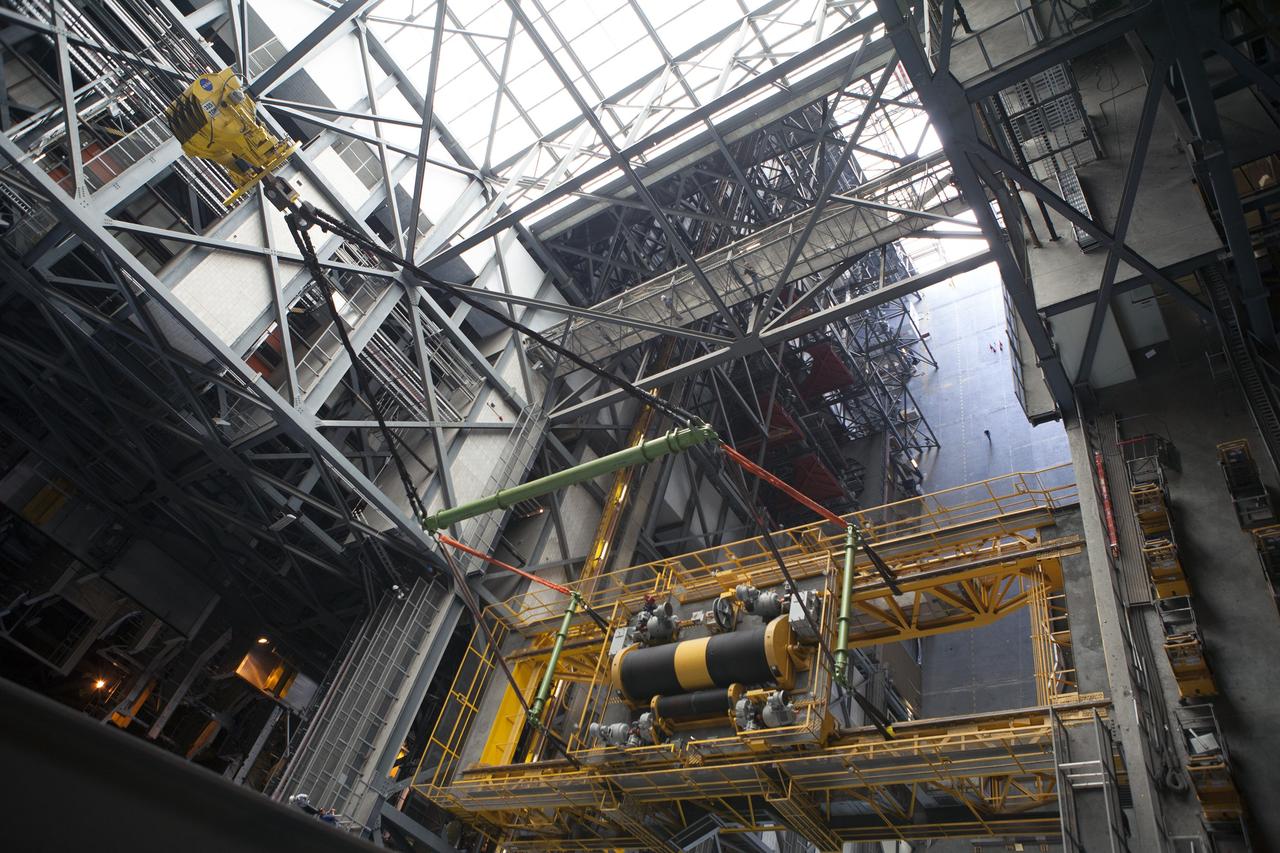 CAPE CANAVERAL, Fla. – Inside the Vehicle Assembly Building, or VAB, at NASA's Kennedy Space Center in Florida, a view from above shows a crane being used to lower the 175-ton crane. The crane is being lowered from Level 16 down to the transfer aisle floor to perform upgrades to its 45-year-old controls in order to improve reliability, precision and safety. The Ground Systems Development and Operations Program is overseeing upgrades and modifications to the VAB. The crane will be upgraded so that it can support lifting needs for NASA and other exploration vehicles, including the agency's Space Launch System and Orion spacecraft. Photo credit: NASA/Daniel Casper