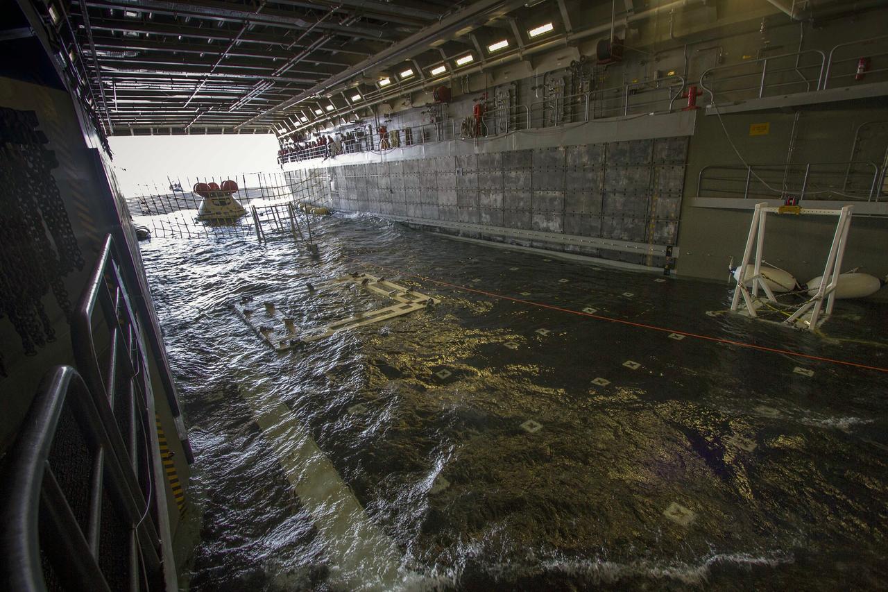 SAN DIEGO, Calif. – The Orion boilerplate test vehicle awaits release from the water-filled well deck of the USS Anchorage during the third day of Orion Underway Recovery Test 3 in the Pacific Ocean.    NASA, Lockheed Martin and U.S. Navy personnel are conducting the recovery test using the test vehicle to prepare for recovery of the Orion crew module on its return from a deep space mission. The test allows the teams to demonstrate and evaluate the recovery processes, procedures, hardware and personnel in open waters. The Ground Systems Development and Operations Program is conducting the underway recovery tests. Orion is the exploration spacecraft designed to carry astronauts to destinations not yet explored by humans, including an asteroid and Mars. It will have emergency abort capability, sustain the crew during space travel and provide safe re-entry from deep space return velocities. The first unpiloted test flight of Orion is scheduled to launch in 2014 atop a United Launch Alliance Delta IV Heavy rocket and in 2018 on NASA’s Space Launch System rocket. For more information, visit http://www.nasa.gov/orion. Photo credit: NASA/Cory Huston
