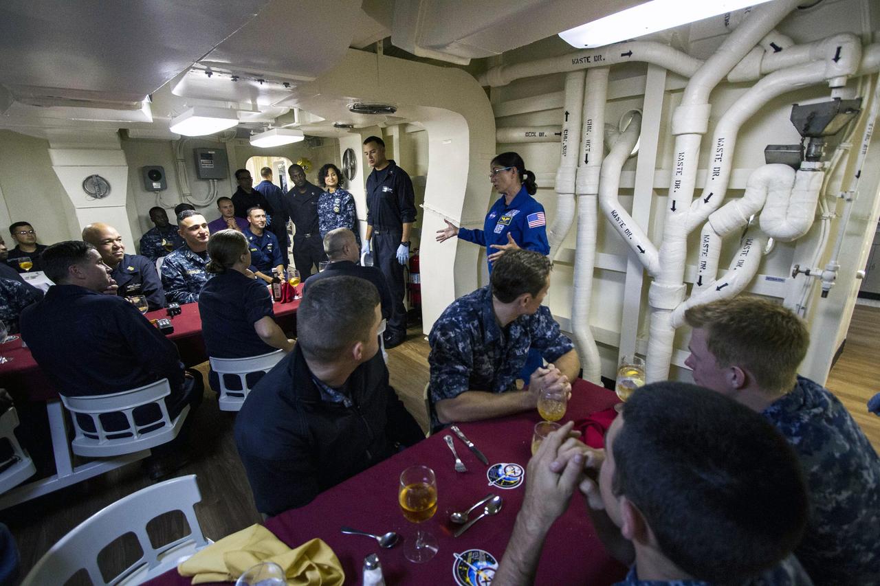SAN DIEGO, Calif. – NASA astronaut Nicole Stott talks to members of the U.S. Navy inside the USS Anchorage during the Orion Underway Recovery Test 3 mission simulation day in the Pacific Ocean. The Orion boilerplate test vehicle is secured in the well deck of the ship.     NASA, Lockheed Martin and U.S. Navy personnel are conducting the recovery test using the test vehicle to prepare for recovery of the Orion crew module on its return from a deep space mission. The test allows the teams to demonstrate and evaluate the recovery processes, procedures, hardware and personnel in open waters. The Ground Systems Development and Operations Program is conducting the underway recovery tests. Orion is the exploration spacecraft designed to carry astronauts to destinations not yet explored by humans, including an asteroid and Mars. It will have emergency abort capability, sustain the crew during space travel and provide safe re-entry from deep space return velocities. The first unpiloted test flight of Orion is scheduled to launch in 2014 atop a United Launch Alliance Delta IV Heavy rocket and in 2018 on NASA’s Space Launch System rocket. For more information, visit http://www.nasa.gov/orion. Photo credit: NASA/Cory Huston