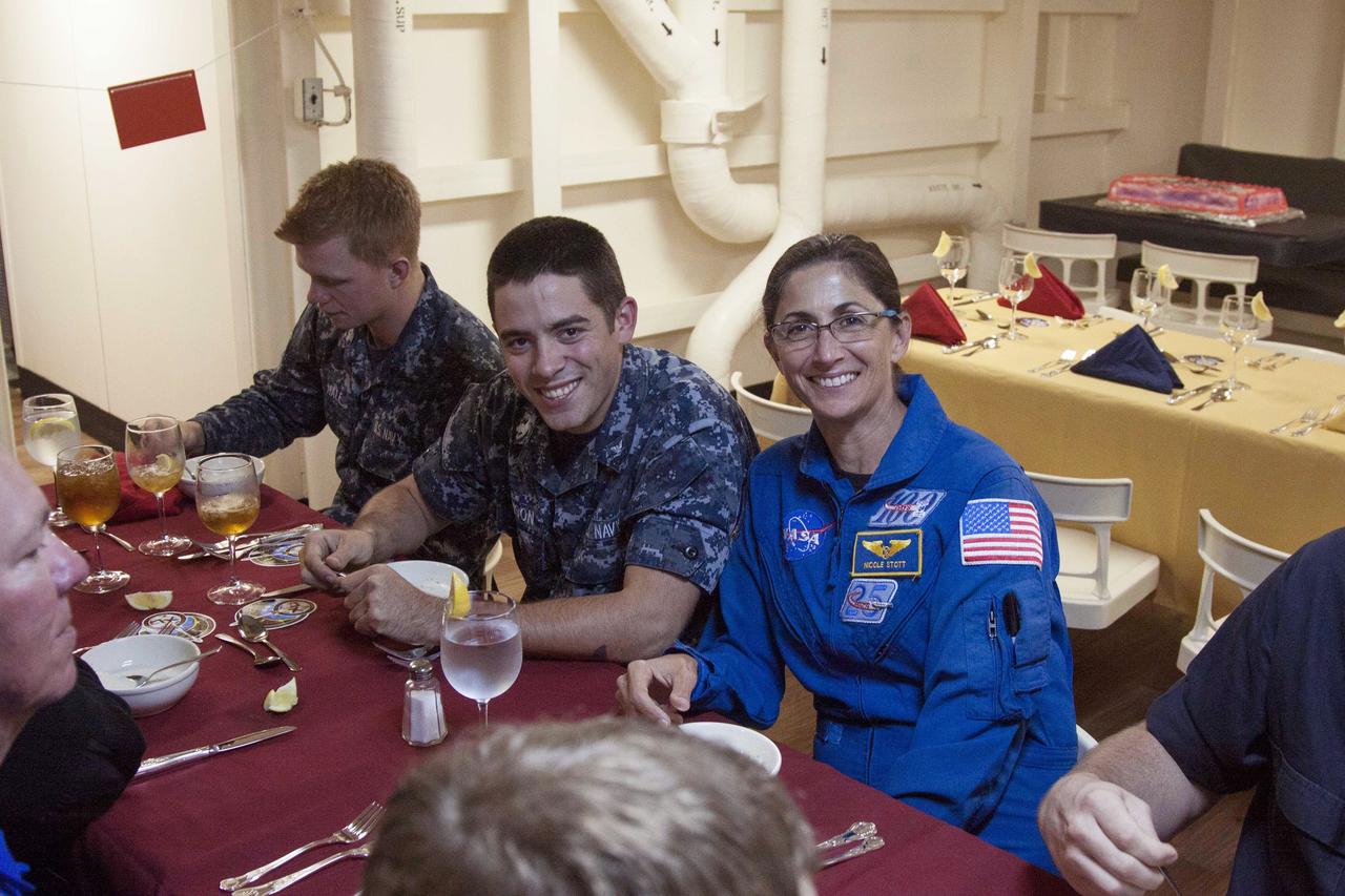 SAN DIEGO, Calif. – NASA astronaut Nicole Stott talks to members of the U.S. Navy inside the USS Anchorage during the Orion Underway Recovery Test 3 mission simulation day in the Pacific Ocean. The Orion boilerplate test vehicle is secured in the well deck of the ship.    NASA, Lockheed Martin and U.S. Navy personnel are conducting the recovery test using the test vehicle to prepare for recovery of the Orion crew module on its return from a deep space mission. The test allows the teams to demonstrate and evaluate the recovery processes, procedures, hardware and personnel in open waters. The Ground Systems Development and Operations Program is conducting the underway recovery tests. Orion is the exploration spacecraft designed to carry astronauts to destinations not yet explored by humans, including an asteroid and Mars. It will have emergency abort capability, sustain the crew during space travel and provide safe re-entry from deep space return velocities. The first unpiloted test flight of Orion is scheduled to launch in 2014 atop a United Launch Alliance Delta IV Heavy rocket and in 2018 on NASA’s Space Launch System rocket. For more information, visit http://www.nasa.gov/orion. Photo credit: NASA/Cory Huston