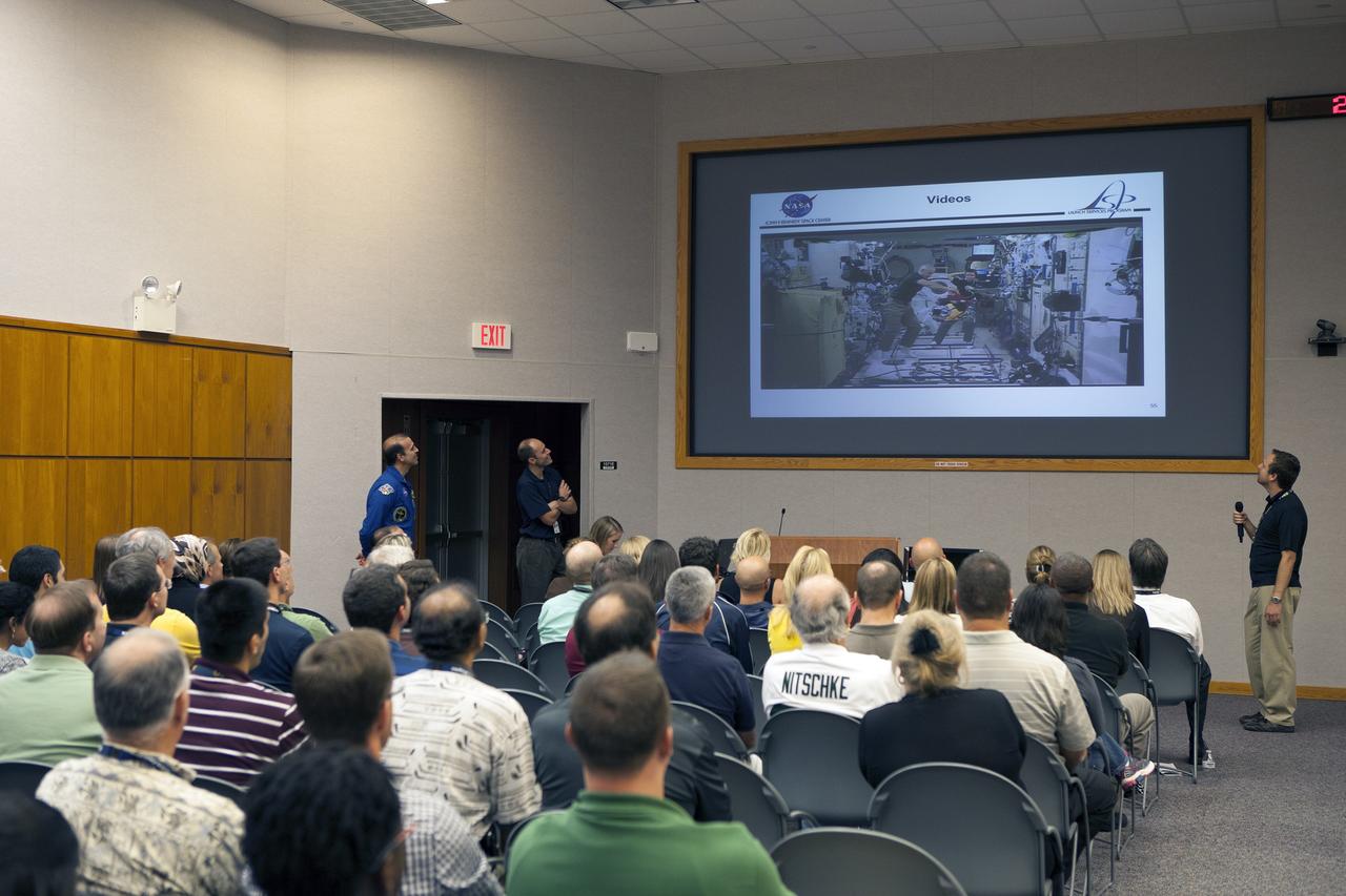 CAPE CANAVERAL, Fla. – NASA astronaut Rick Mastracchio, standing at left, illustrates the fine points of conducting the Slosh experiment on the International Space Station for employees attending the Launch Services Program's All Hands meeting in the Neil Armstrong Operations and Checkout Building Mission Briefing Room at NASA's Kennedy Space Center in Florida.    An Expedition 38/39 crew member, Mastracchio launched to the station from the Baikonur Cosmodrome in Kazakhstan on Nov. 6, 2013, and returned to Earth on May 13, 2014, after 188 days in space. To read Mastracchio's biography, visit http://www.jsc.nasa.gov/Bios/htmlbios/mastracc.html. For more information on the Slosh experiment, visit http://www.nasa.gov/content/slosh-experiment-designed-to-improve-rocket-safety-efficiency/. Photo credit: NASA/Daniel Casper