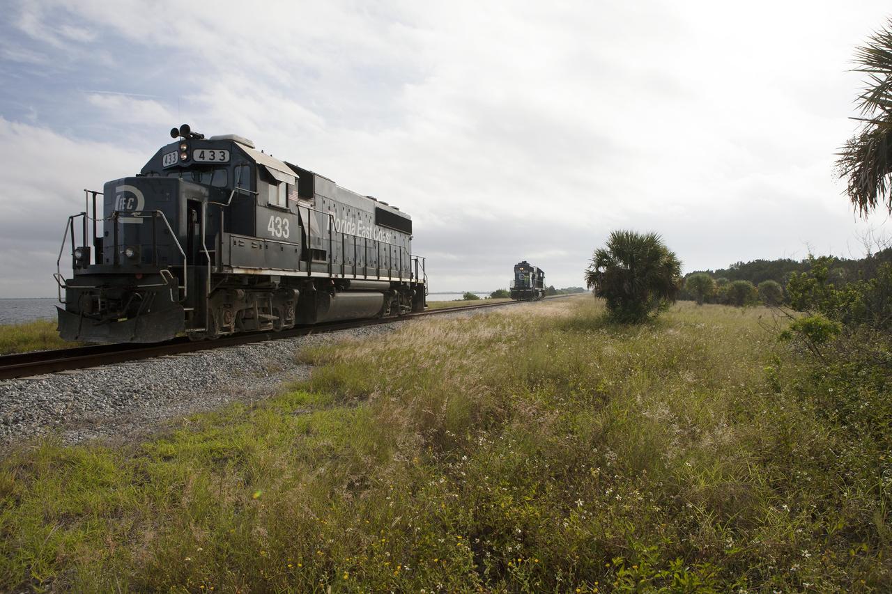 CAPE CANAVERAL, Fla. – Operations are underway to couple Florida East Coast Railway, or FEC, locomotives No. 433 and No. 428 on the track alongside the Indian River, north of Launch Complex 39 at NASA’s Kennedy Space Center in Florida. Kennedy's Center Planning and Development Directorate has enlisted the locomotives to support a Rail Vibration Test for the Canaveral Port Authority.    The purpose of the test is to collect amplitude, frequency and vibration test data utilizing two Florida East Coast locomotives operating on KSC tracks to ensure that future railroad operations will not affect launch vehicle processing at the center. Buildings instrumented for the test include the Rotation Processing Surge Facility, Thermal Protection Systems Facility, Vehicle Assembly Building, Orbiter Processing Facility and Booster Fabrication Facility. Photo credit: NASA/Daniel Casper