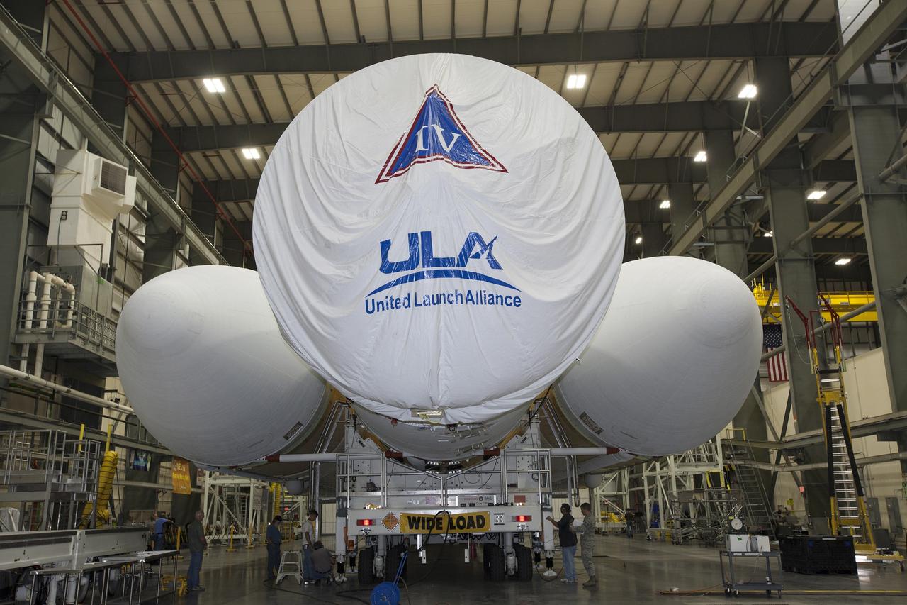 CAPE CANAVERAL, Fla. – Inside the Horizontal Integration Facility at Space Launch Complex 37 at Cape Canaveral Air Force Station in Florida, United Launch Alliance technicians prepare the Delta IV Heavy rocket for rollout to the pad. The rocket is secured on the Elevated Platform Transporter for the trip to the pad. The Delta IV Heavy will launch Orion on Exploration Flight Test-1. During its first flight test, Orion will travel farther into space than any human spacecraft has gone in more than 40 years. The data gathered during the flight will influence design decisions, validate existing computer models and innovative new approaches to space systems development, as well as reduce overall mission risks and costs for later Orion flights. Liftoff of Orion on the first flight test is planned for December 2014. Photo credit: NASA/Dimitri Gerondidakis