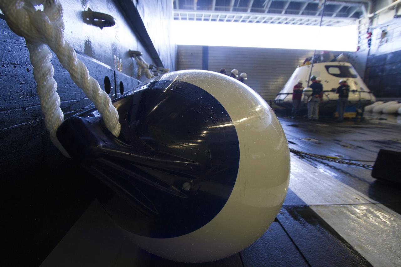 SAN DIEGO, Calif. – Underway Recovery Test team members help secure the Orion boilerplate test vehicle in the well deck of the USS Anchorage during the first day of Underway Recovery Test 3 in the Pacific Ocean. NASA, Lockheed Martin and U.S. Navy personnel are conducting the recovery test to prepare for recovery of the Orion crew module on its return from a deep space mission. The test allows the teams to demonstrate and evaluate the recovery processes, procedures, hardware and personnel in open waters.    The Ground Systems Development and Operations Program is conducting the underway recovery tests. Orion is the exploration spacecraft designed to carry astronauts to destinations not yet explored by humans, including an asteroid and Mars. It will have emergency abort capability, sustain the crew during space travel and provide safe re-entry from deep space return velocities. The first unpiloted test flight of Orion is scheduled to launch in 2014 atop a United Launch Alliance Delta IV Heavy rocket and in 2018 on NASA’s Space Launch System rocket. For more information, visit http://www.nasa.gov/orion. Photo credit: NASA/Cory Huston