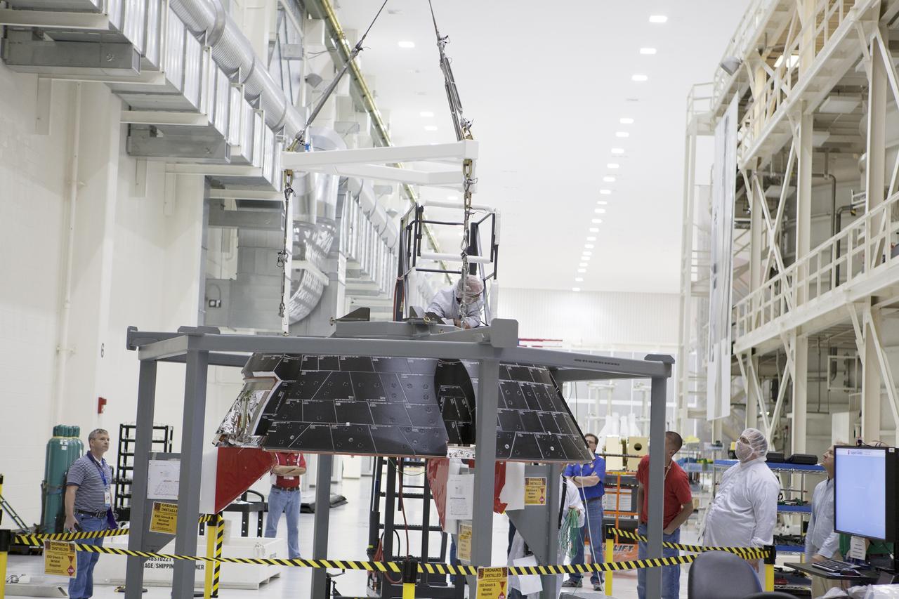 CAPE CANAVERAL, Fla. – Inside the Neil Armstrong Operations and Checkout Building high bay at NASA’s Kennedy Space Center in Florida, Lockheed Martin technicians prepare to do a fit check of the forward bay cover for the Orion crew module. The cover is a shell that fits over Orion's crew module to protect the spacecraft during launch, orbital flight and re-entry into Earth's atmosphere. When Orion returns from space, the cover must be jettisoned high above the ground so that the parachutes can deploy and unfurl. Orion is the exploration spacecraft designed to carry astronauts to destinations not yet explored by humans, including an asteroid and Mars. It will have emergency abort capability, sustain the crew during space travel and provide safe re-entry from deep space return velocities. The first unpiloted flight test of Orion is scheduled to launch in December 2014 atop a United Launch Alliance Delta IV Heavy rocket and in 2018 on NASA’s Space Launch System rocket. For more information, visit http://www.nasa.gov/orion. Photo credit: NASA/Daniel Casper