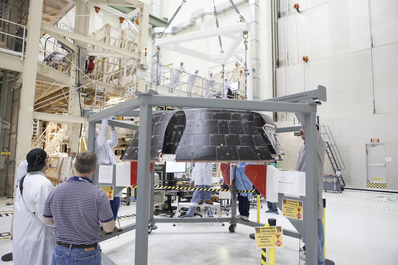 CAPE CANAVERAL, Fla. – Inside the Neil Armstrong Operations and Checkout Building high bay at NASA’s Kennedy Space Center in Florida, Lockheed Martin technicians prepare to do a fit check of the forward bay cover for the Orion crew module. The cover is a shell that fits over Orion's crew module to protect the spacecraft during launch, orbital flight and re-entry into Earth's atmosphere. When Orion returns from space, the cover must be jettisoned high above the ground so that the parachutes can deploy and unfurl. Orion is the exploration spacecraft designed to carry astronauts to destinations not yet explored by humans, including an asteroid and Mars. It will have emergency abort capability, sustain the crew during space travel and provide safe re-entry from deep space return velocities. The first unpiloted flight test of Orion is scheduled to launch in December 2014 atop a United Launch Alliance Delta IV Heavy rocket and in 2018 on NASA’s Space Launch System rocket. For more information, visit http://www.nasa.gov/orion. Photo credit: NASA/Daniel Casper
