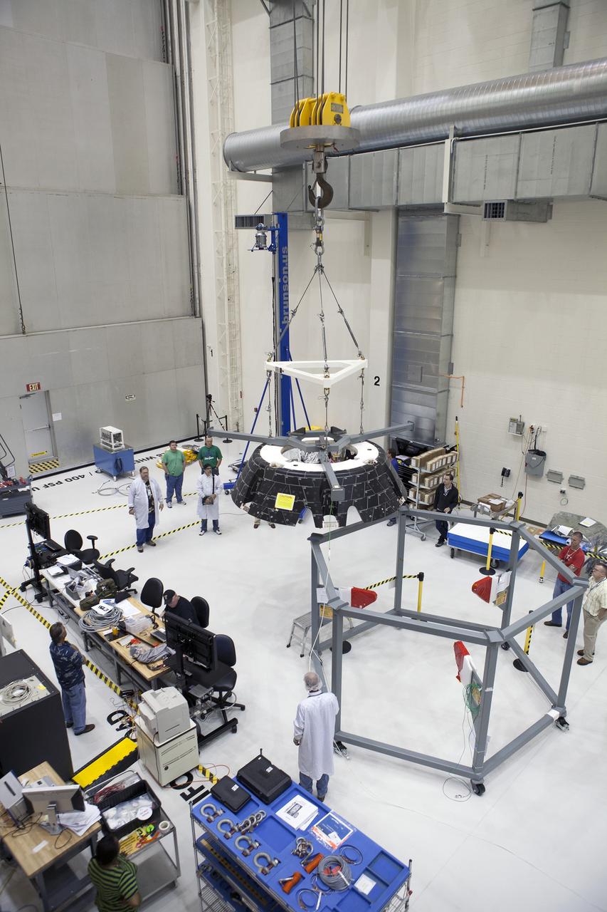 CAPE CANAVERAL, Fla. – Inside the Neil Armstrong Operations and Checkout Building high bay at NASA’s Kennedy Space Center in Florida, Lockheed Martin technicians monitor the progress as a crane lifts the forward bay cover for a fit check on the Orion crew module. The cover is a shell that fits over Orion's crew module to protect the spacecraft during launch, orbital flight and re-entry into Earth's atmosphere. When Orion returns from space, the cover must be jettisoned high above the ground so that the parachutes can deploy and unfurl. Orion is the exploration spacecraft designed to carry astronauts to destinations not yet explored by humans, including an asteroid and Mars. It will have emergency abort capability, sustain the crew during space travel and provide safe re-entry from deep space return velocities. The first unpiloted flight test of Orion is scheduled to launch in December 2014 atop a United Launch Alliance Delta IV Heavy rocket and in 2018 on NASA’s Space Launch System rocket. For more information, visit http://www.nasa.gov/orion. Photo credit: NASA/Daniel Casper