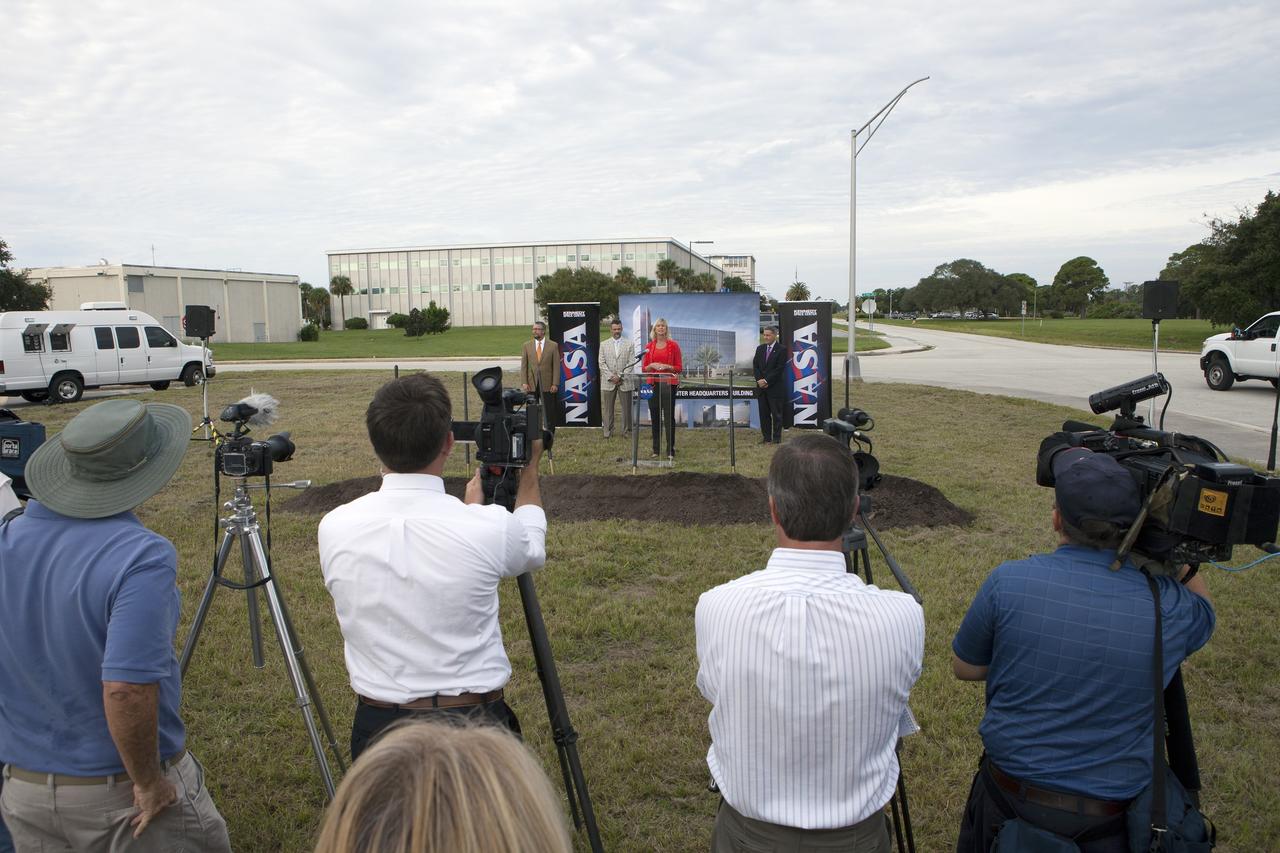 CAPE CANAVERAL, Fla. – Groundbreaking for the new Central Campus took place in the Industrial Area at NASA's Kennedy Space Center in Florida. Nancy Bray, director of Kennedy's Center Operations Directorate, speaks to members of the media and guests during the ceremony. To her right is Kennedy Center Director Bob Cabana. From far left, are Steve Belflower, vice president of HuntonBrady Architects of Orlando, and Kirk Hazen, southeast district manager and vice president of Hensel Phelps, the construction contractor.     Kennedy is transforming into a multi-user, 21st century spaceport supporting both commercial and government users and operations. Central Campus Phase I includes construction of a new Headquarters Building as one of the major components of the strategy. The new Headquarters Building will be a seven-story, 200,000-square-foot facility that will house about 500 NASA civil service and contractor employees. Photo credit: NASA/Kim Shiflett