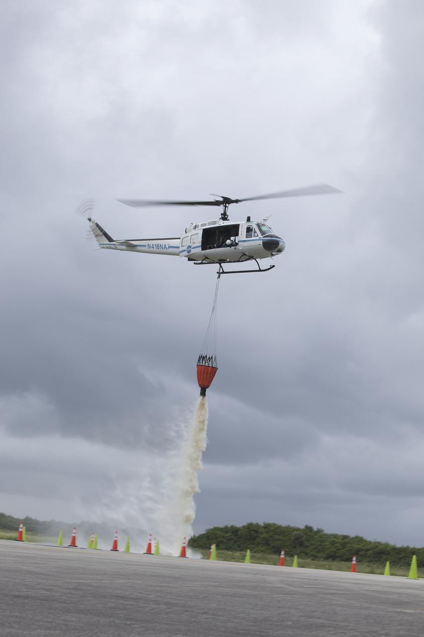 CAPE CANAVERAL, Fla. -- At NASA's Kennedy Space Center in Florida, a three-person helicopter crew recently practiced using a Bambi Bucket to pick up water from a nearby waterway and dropping it on simulated targets at the center’s Shuttle Landing Facility. Firefighters respond to wildfires with teams on the ground and in the air. The most up-to-date tools include helicopters that use Bambi Buckets large quantities of water. NASA Flight Operations teams are training to perfect the skills needed to ensure they are ready to use tools, such as the Bambi Bucket, in the event of an out-of-control blaze at the spaceport. Photo credit: NASA/Frankie Martin