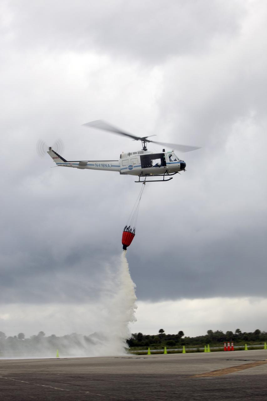 CAPE CANAVERAL, Fla. -- At NASA's Kennedy Space Center in Florida, a three-person helicopter crew recently practiced using a Bambi Bucket to pick up water from a nearby waterway and dropping it on simulated targets at the center’s Shuttle Landing Facility. Firefighters respond to wildfires with teams on the ground and in the air. The most up-to-date tools include helicopters that use Bambi Buckets large quantities of water. NASA Flight Operations teams are training to perfect the skills needed to ensure they are ready to use tools, such as the Bambi Bucket, in the event of an out-of-control blaze at the spaceport. Photo credit: NASA/Frankie Martin