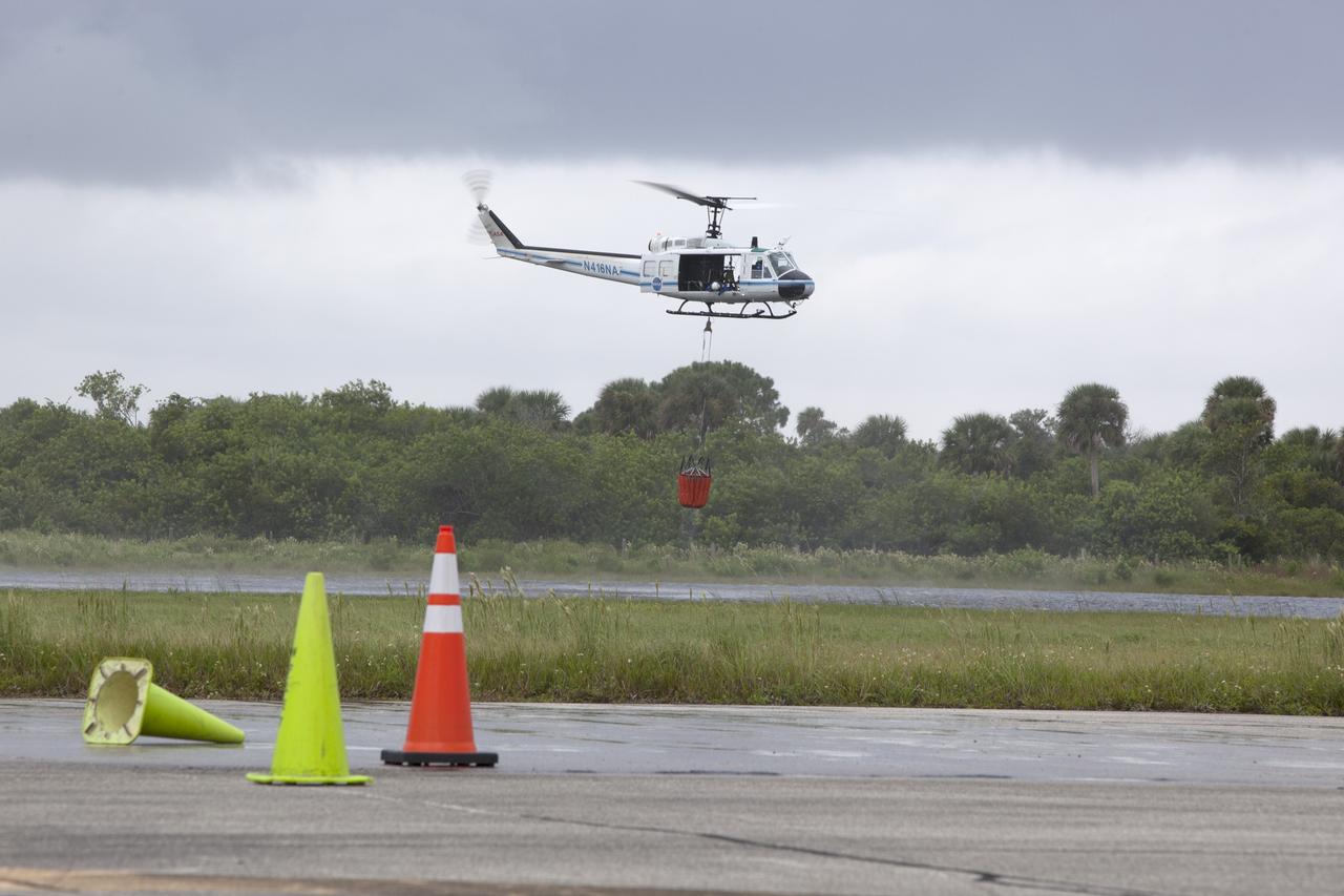 CAPE CANAVERAL, Fla. -- At NASA's Kennedy Space Center in Florida, the crew of the NASA helicopter carefully lifts a Bambi Bucket from a canal near the Shuttle Landing Facility. Minutes later, the water was dropped on the target cones in the foreground, using techniques that would be employed to fight a brush fire at the Kennedy Space Center. Firefighters respond to wildfires with teams on the ground and in the air. The most up-to-date tools include helicopters that use Bambi Buckets large quantities of water. NASA Flight Operations teams are training to perfect the skills needed to ensure they are ready to use tools, such as the Bambi Bucket, in the event of an out-of-control blaze at the spaceport. Photo credit: NASA/Frankie Martin