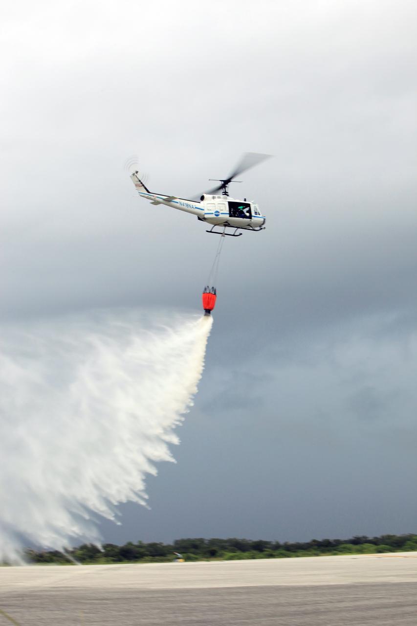 CAPE CANAVERAL, Fla. -- At NASA's Kennedy Space Center in Florida, a three-person helicopter crew recently practiced using a Bambi Bucket to pick up water from a nearby waterway and dropping it on simulated targets at the center’s Shuttle Landing Facility. Firefighters respond to wildfires with teams on the ground and in the air. The most up-to-date tools include helicopters that use Bambi Buckets large quantities of water. NASA Flight Operations teams are training to perfect the skills needed to ensure they are ready to use tools, such as the Bambi Bucket, in the event of an out-of-control blaze at the spaceport. Photo credit: NASA/Frankie Martin
