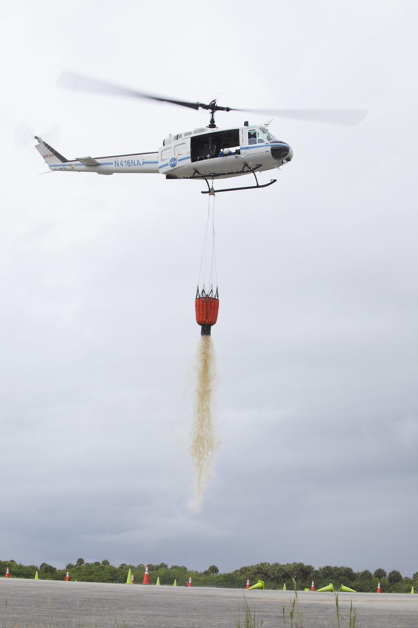CAPE CANAVERAL, Fla. -- At NASA's Kennedy Space Center in Florida, a three-person helicopter crew recently practiced using a Bambi Bucket to pick up water from a nearby waterway and dropping it on simulated targets at the center’s Shuttle Landing Facility. Firefighters respond to wildfires with teams on the ground and in the air. The most up-to-date tools include helicopters that use Bambi Buckets large quantities of water. NASA Flight Operations teams are training to perfect the skills needed to ensure they are ready to use tools, such as the Bambi Bucket, in the event of an out-of-control blaze at the spaceport. Photo credit: NASA/Frankie Martin