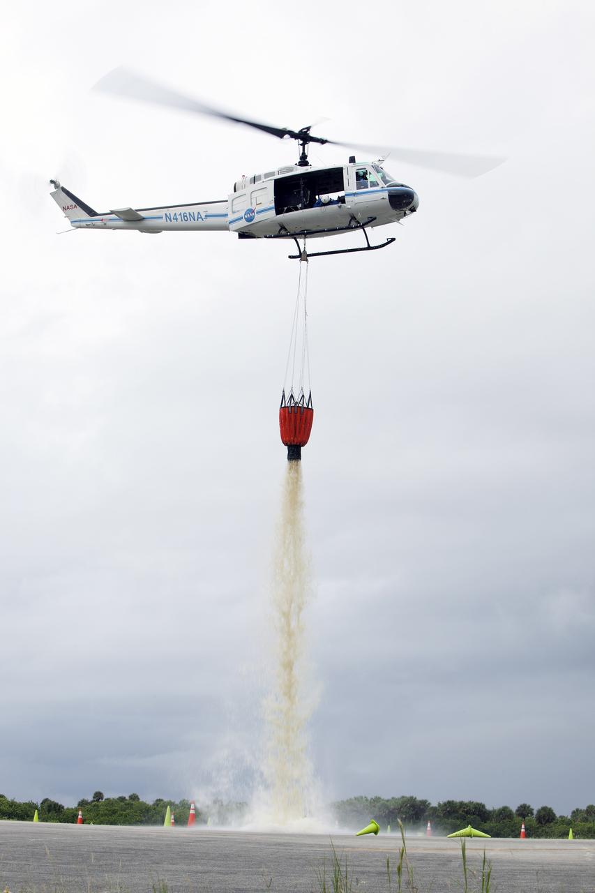CAPE CANAVERAL, Fla. -- At NASA's Kennedy Space Center in Florida, a three-person helicopter crew recently practiced using a Bambi Bucket to pick up water from a nearby waterway and dropping it on simulated targets at the center’s Shuttle Landing Facility. Firefighters respond to wildfires with teams on the ground and in the air. The most up-to-date tools include helicopters that use Bambi Buckets large quantities of water. NASA Flight Operations teams are training to perfect the skills needed to ensure they are ready to use tools, such as the Bambi Bucket, in the event of an out-of-control blaze at the spaceport. Photo credit: NASA/Frankie Martin