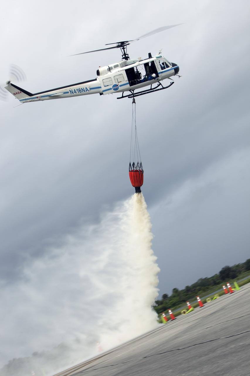 CAPE CANAVERAL, Fla. -- At NASA's Kennedy Space Center in Florida, a three-person helicopter crew recently practiced using a Bambi Bucket to pick up water from a nearby waterway and dropping it on simulated targets at the center’s Shuttle Landing Facility. Firefighters respond to wildfires with teams on the ground and in the air. The most up-to-date tools include helicopters that use Bambi Buckets large quantities of water. NASA Flight Operations teams are training to perfect the skills needed to ensure they are ready to use tools, such as the Bambi Bucket, in the event of an out-of-control blaze at the spaceport. Photo credit: NASA/Frankie Martin