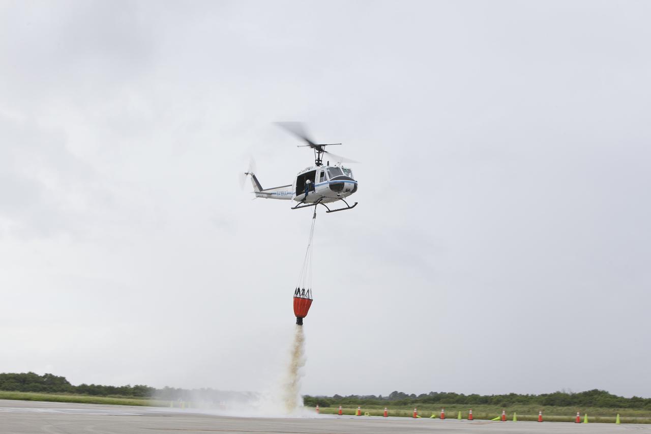 CAPE CANAVERAL, Fla. -- At NASA's Kennedy Space Center in Florida, a three-person helicopter crew recently practiced using a Bambi Bucket to pick up water from a nearby waterway and dropping it on simulated targets at the center’s Shuttle Landing Facility. Firefighters respond to wildfires with teams on the ground and in the air. The most up-to-date tools include helicopters that use Bambi Buckets large quantities of water. NASA Flight Operations teams are training to perfect the skills needed to ensure they are ready to use tools, such as the Bambi Bucket, in the event of an out-of-control blaze at the spaceport. Photo credit: NASA/Frankie Martin