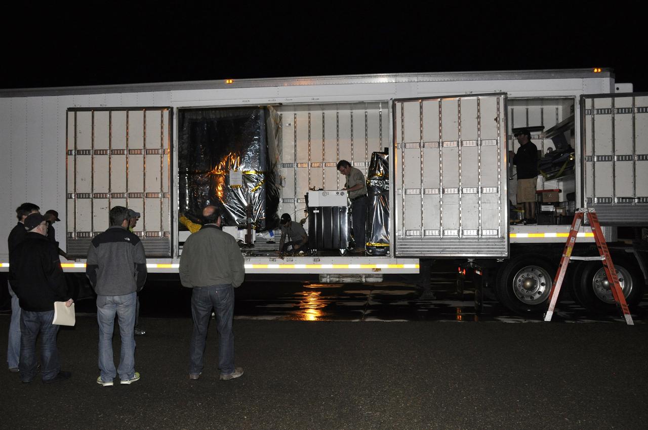 VANDENBERG AIR FORCE BASE, Calif. – Workers are standing by to assist with the offloading of NASA's Soil Moisture Active Passive, or SMAP, spacecraft from the truck that delivered it from the Jet Propulsion Laboratory in Pasadena, California, to the Astrotech payload processing facility on Vandenberg Air Force Base in California.    SMAP will launch on a Delta II 7320 configuration vehicle featuring a United Launch Alliance first stage booster powered by an Aerojet Rocketdyne RS-27A main engine and three Alliant Techsystems, or ATK, strap-on solid rocket motors. Once on station in Earth orbit, SMAP will provide global measurements of soil moisture and its freeze/thaw state. These measurements will be used to enhance understanding of processes that link the water, energy and carbon cycles, and to extend the capabilities of weather and climate prediction models. SMAP data also will be used to quantify net carbon flux in boreal landscapes and to develop improved flood prediction and drought monitoring capabilities. Launch from Space Launch Complex 2 is targeted for Jan. 29, 2015. To learn more about SMAP, visit http://smap.jpl.nasa.gov.  Photo credit: NASA/Randy Beaudoin