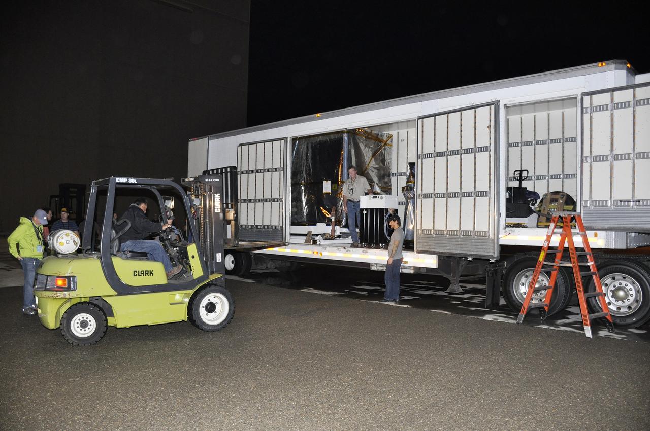 VANDENBERG AIR FORCE BASE, Calif. – A forklift is moved into place to assist with the offloading of NASA's Soil Moisture Active Passive, or SMAP, spacecraft from the truck that delivered it from the Jet Propulsion Laboratory in Pasadena, California, to the Astrotech payload processing facility on Vandenberg Air Force Base in California.    SMAP will launch on a Delta II 7320 configuration vehicle featuring a United Launch Alliance first stage booster powered by an Aerojet Rocketdyne RS-27A main engine and three Alliant Techsystems, or ATK, strap-on solid rocket motors. Once on station in Earth orbit, SMAP will provide global measurements of soil moisture and its freeze/thaw state. These measurements will be used to enhance understanding of processes that link the water, energy and carbon cycles, and to extend the capabilities of weather and climate prediction models. SMAP data also will be used to quantify net carbon flux in boreal landscapes and to develop improved flood prediction and drought monitoring capabilities. Launch from Space Launch Complex 2 is targeted for Jan. 29, 2015. To learn more about SMAP, visit http://smap.jpl.nasa.gov.  Photo credit: NASA/Randy Beaudoin