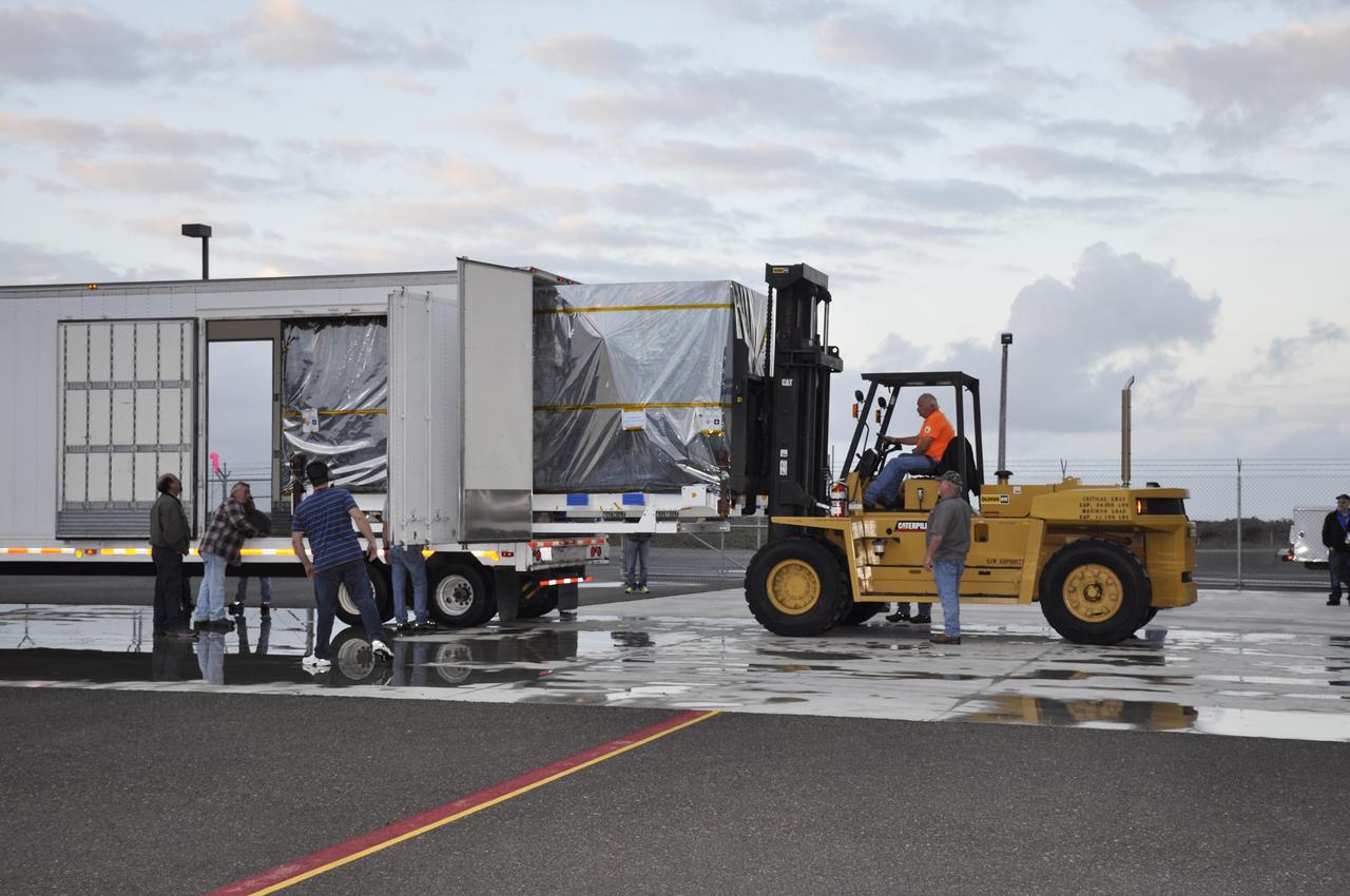 VANDENBERG AIR FORCE BASE, Calif. – The transportation container protecting NASA's Soil Moisture Active Passive, or SMAP, spacecraft is offloaded from the truck that delivered it from the Jet Propulsion Laboratory in Pasadena, California, to the Astrotech payload processing facility on Vandenberg Air Force Base in California with the aid of a forklift.    SMAP will launch on a Delta II 7320 configuration vehicle featuring a United Launch Alliance first stage booster powered by an Aerojet Rocketdyne RS-27A main engine and three Alliant Techsystems, or ATK, strap-on solid rocket motors. Once on station in Earth orbit, SMAP will provide global measurements of soil moisture and its freeze/thaw state. These measurements will be used to enhance understanding of processes that link the water, energy and carbon cycles, and to extend the capabilities of weather and climate prediction models. SMAP data also will be used to quantify net carbon flux in boreal landscapes and to develop improved flood prediction and drought monitoring capabilities. Launch from Space Launch Complex 2 is targeted for Jan. 29, 2015. To learn more about SMAP, visit http://smap.jpl.nasa.gov.  Photo credit: NASA/Randy Beaudoin