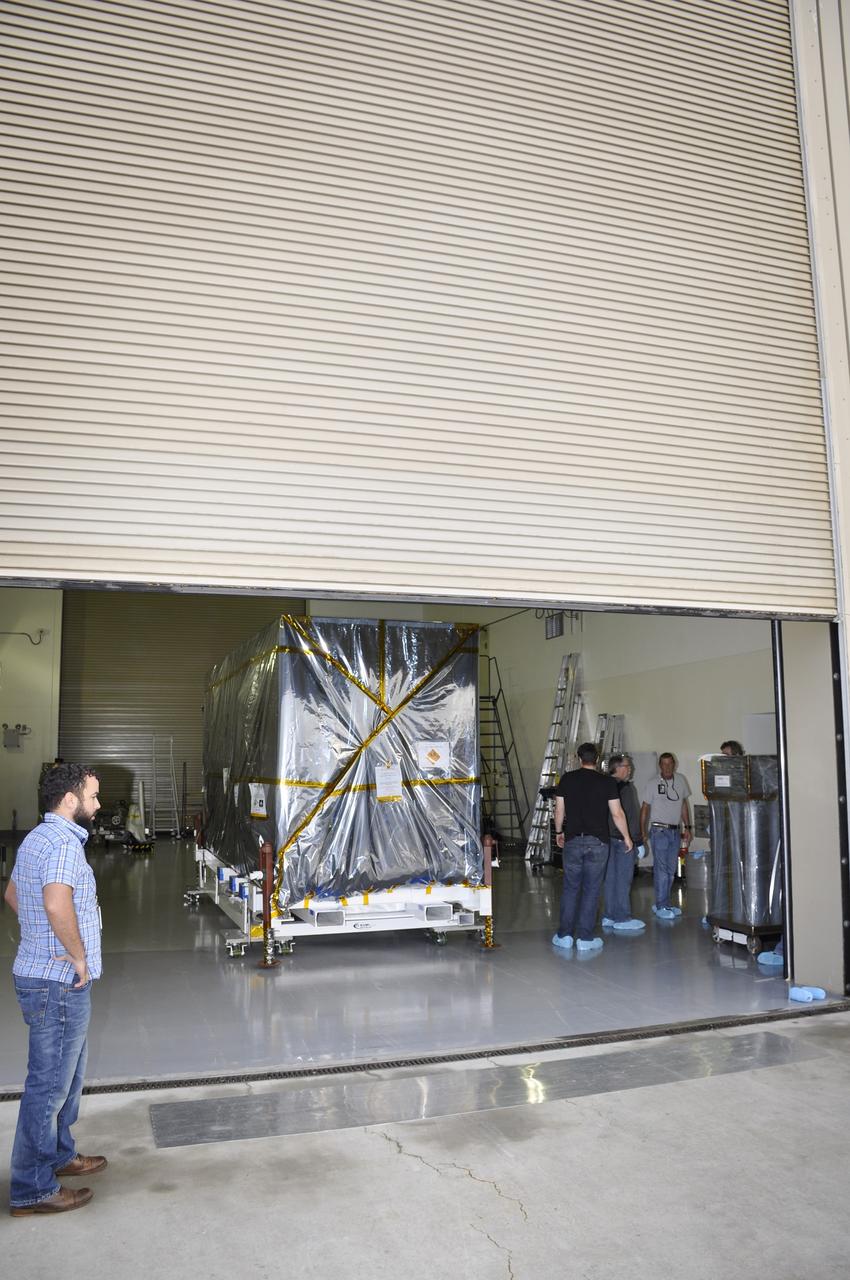 VANDENBERG AIR FORCE BASE, Calif. – NASA's Soil Moisture Active Passive, or SMAP, spacecraft, still protected in its transportation container, arrives in the Astrotech payload processing facility at Vandenberg Air Force Base in California, completing its journey from the Jet Propulsion Laboratory in Pasadena, California.    SMAP will launch on a Delta II 7320 configuration vehicle featuring a United Launch Alliance first stage booster powered by an Aerojet Rocketdyne RS-27A main engine and three Alliant Techsystems, or ATK, strap-on solid rocket motors. Once on station in Earth orbit, SMAP will provide global measurements of soil moisture and its freeze/thaw state. These measurements will be used to enhance understanding of processes that link the water, energy and carbon cycles, and to extend the capabilities of weather and climate prediction models. SMAP data also will be used to quantify net carbon flux in boreal landscapes and to develop improved flood prediction and drought monitoring capabilities. Launch from Space Launch Complex 2 is targeted for Jan. 29, 2015. To learn more about SMAP, visit http://smap.jpl.nasa.gov.  Photo credit: NASA/Randy Beaudoin