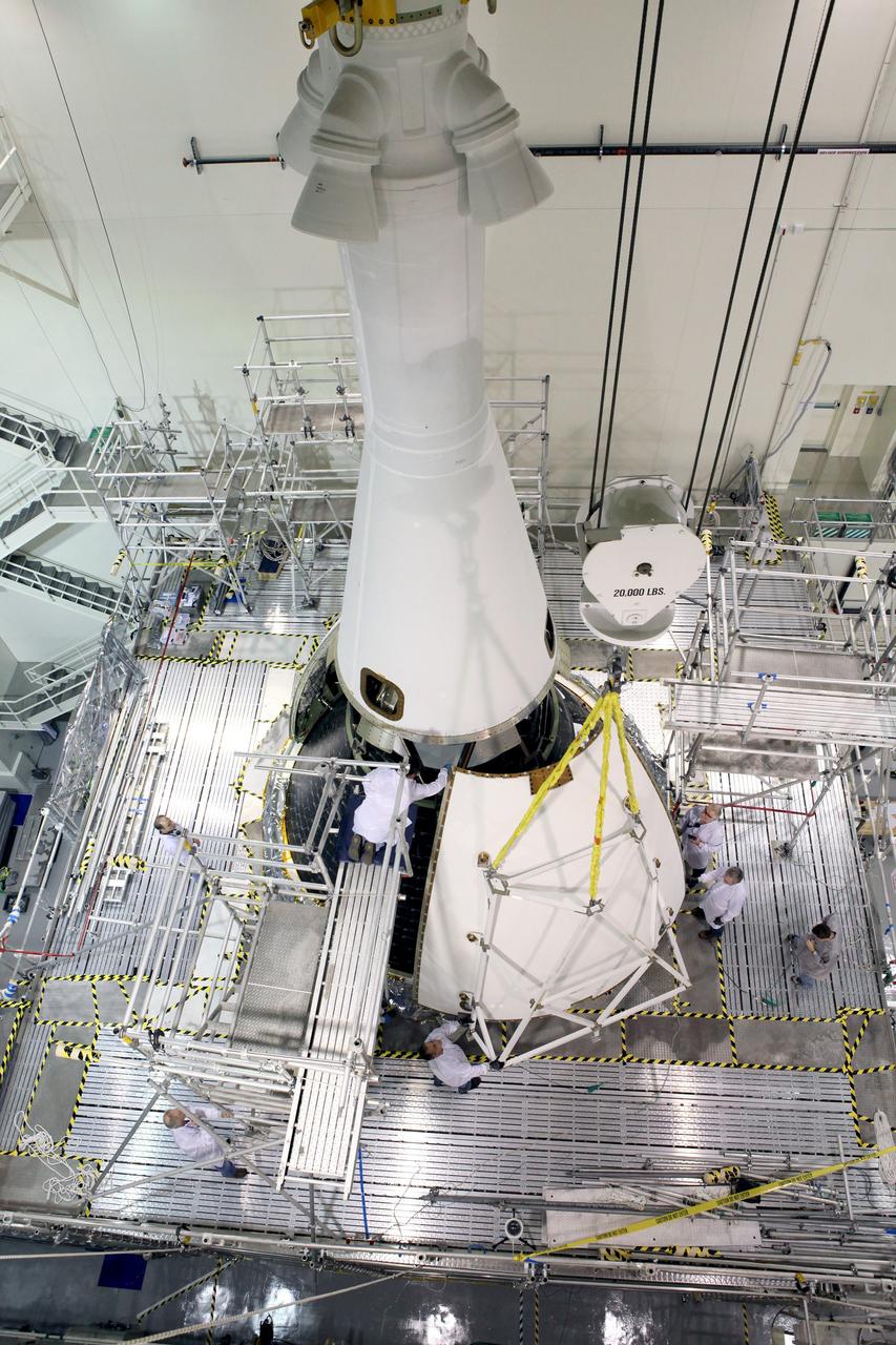 CAPE CANAVERAL, Fla. – Technicians on work platforms continue the installation of four Ogive panels on Orion's Launch Abort System inside the Launch Abort System Facility at NASA’s Kennedy Space Center in Florida. The panels will smooth the airflow over the conical spacecraft to limit sound and vibration, which will make for a much smoother ride for the astronauts who will ride inside Orion in the future. The work marked the final major assembly steps for the spacecraft before it is transported to Space Launch Complex 37 at Cape Canaveral Air Force Station in November. Orion is the exploration spacecraft designed to carry astronauts to destinations not yet explored by humans, including an asteroid and Mars. It will have emergency abort capability, sustain the crew during space travel and provide safe re-entry from deep space return velocities. The first unpiloted flight test of Orion is scheduled to launch in December 2014 atop a United Launch Alliance Delta IV Heavy rocket, and in 2018 on NASA’s Space Launch System rocket. For more information, visit www.nasa.gov/orion. Photo credit: Daniel Casper