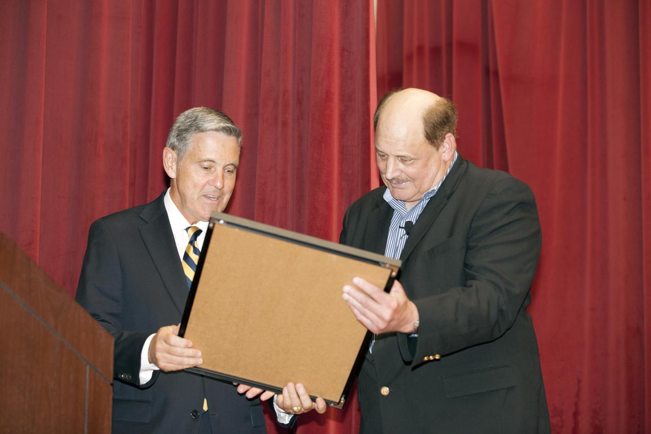CAPE CANAVERAL, Fla. – NASA Kennedy Space Center Director Bob Cabana, left, presents a special plaque to Michael Kersjes, author and former special education teacher and football coach from Michigan, after his presentation to workers during the Disability Awareness and Action Working Group, or DAAWG, event. The theme of Kersjes' presentation was "Power of the Human Spirit."    Kersjes is the author of the book, "A Smile as Big as the Moon," which told the true story of how he worked to get special education students into Space Camp, a competitive education program at the U.S. Space and Rocket Center in Huntsville, Alabama. His book was made into a movie in 2012. For information on Kennedy's diversity programs, visit http://odeo.ksc.nasa.gov. Photo credit: NASA/Kim Shiflett