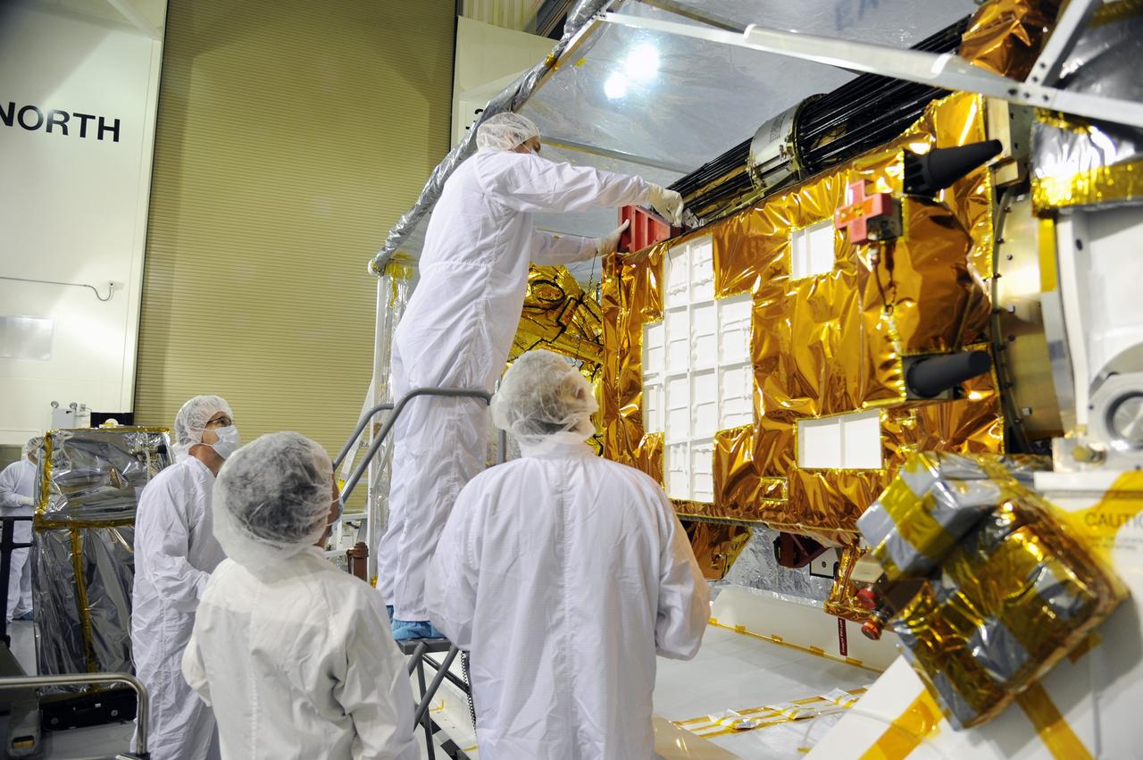 VANDENBERG AIR FORCE BASE, Calif. – Workers prepare to inspect instrument and optics covers on NASA's Soil Moisture Active Passive, or SMAP, spacecraft in the Astrotech payload processing facility on Vandenberg Air Force Base in California during a post-shipment inspection. The spacecraft was delivered to the launch site today from NASA's Jet Propulsion Laboratory in Pasadena, California. SMAP will launch on a Delta II 7320 configuration vehicle featuring a United Launch Alliance first stage booster powered by an Aerojet Rocketdyne RS-27A main engine and three Alliant Techsystems, or ATK, strap-on solid rocket motors. Once on station in Earth orbit, SMAP will provide global measurements of soil moisture and its freeze/thaw state. These measurements will be used to enhance understanding of processes that link the water, energy and carbon cycles, and to extend the capabilities of weather and climate prediction models. SMAP data also will be used to quantify net carbon flux in boreal landscapes and to develop improved flood prediction and drought monitoring capabilities. Launch from Space Launch Complex 2 is targeted for Jan. 29, 2015. To learn more about SMAP, visit http://smap.jpl.nasa.gov. Photo credit: NASA/Robert Rasmison