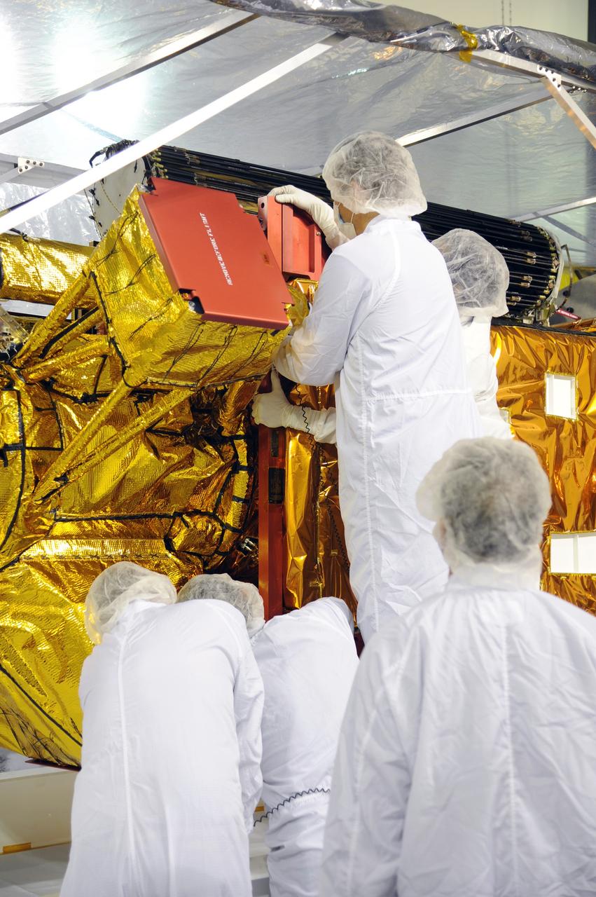 VANDENBERG AIR FORCE BASE, Calif. – Workers inspect instrument and optics covers on NASA's Soil Moisture Active Passive, or SMAP, spacecraft in the Astrotech payload processing facility on Vandenberg Air Force Base in California during a post-shipment inspection. The spacecraft was delivered to the launch site today from NASA's Jet Propulsion Laboratory in Pasadena, California.    SMAP will launch on a Delta II 7320 configuration vehicle featuring a United Launch Alliance first stage booster powered by an Aerojet Rocketdyne RS-27A main engine and three Alliant Techsystems, or ATK, strap-on solid rocket motors. Once on station in Earth orbit, SMAP will provide global measurements of soil moisture and its freeze/thaw state. These measurements will be used to enhance understanding of processes that link the water, energy and carbon cycles, and to extend the capabilities of weather and climate prediction models. SMAP data also will be used to quantify net carbon flux in boreal landscapes and to develop improved flood prediction and drought monitoring capabilities. Launch from Space Launch Complex 2 is targeted for Jan. 29, 2015. To learn more about SMAP, visit http://smap.jpl.nasa.gov.  Photo credit: NASA/Robert Rasmison