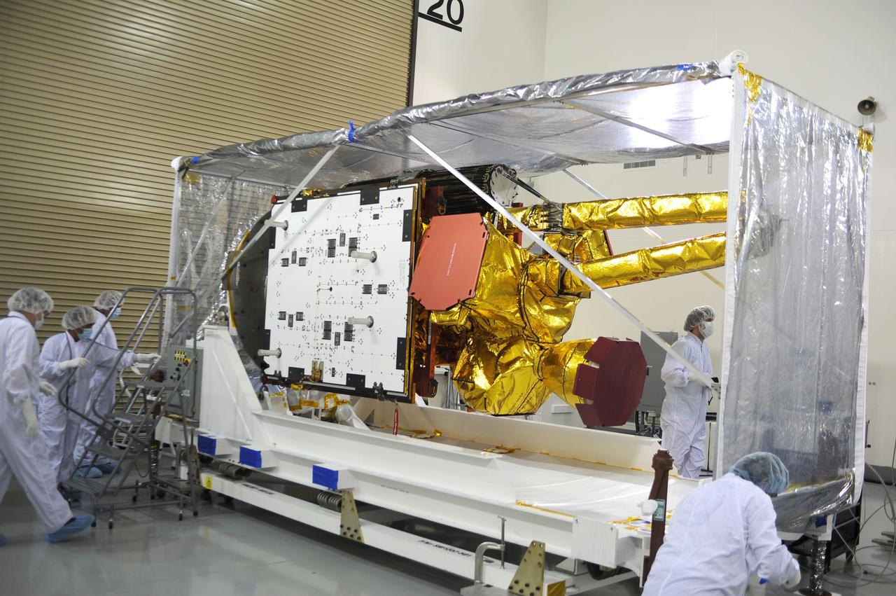 VANDENBERG AIR FORCE BASE, Calif. – Inside the Astrotech payload processing facility on Vandenberg Air Force Base in California, engineers and technicians remove a protective covering from NASA's Soil Moisture Active Passive, or SMAP, spacecraft.    SMAP will launch on a Delta II 7320 configuration vehicle featuring a United Launch Alliance first stage booster powered by an Aerojet Rocketdyne RS-27A main engine and three Alliant Techsystems, or ATK, strap-on solid rocket motors. Once on station in Earth orbit, SMAP will provide global measurements of soil moisture and its freeze/thaw state. These measurements will be used to enhance understanding of processes that link the water, energy and carbon cycles, and to extend the capabilities of weather and climate prediction models. SMAP data also will be used to quantify net carbon flux in boreal landscapes and to develop improved flood prediction and drought monitoring capabilities. Launch from Space Launch Complex 2 is targeted for Jan. 29, 2015. To learn more about SMAP, visit http://smap.jpl.nasa.gov Photo credit: NASA/ Robert Rasmison